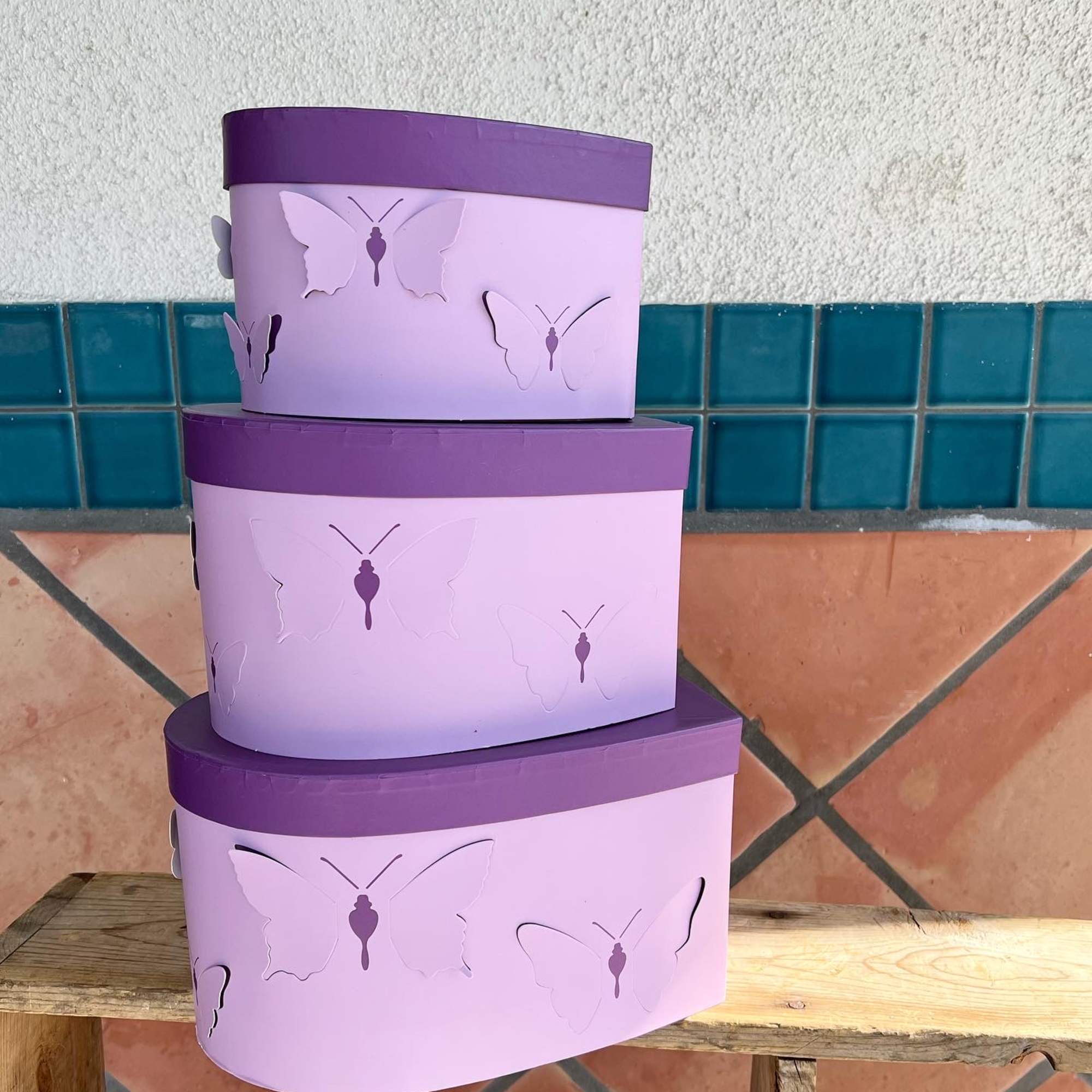 pink/lavender/purple flowers arranged inside a heart shape box with butterflies on the