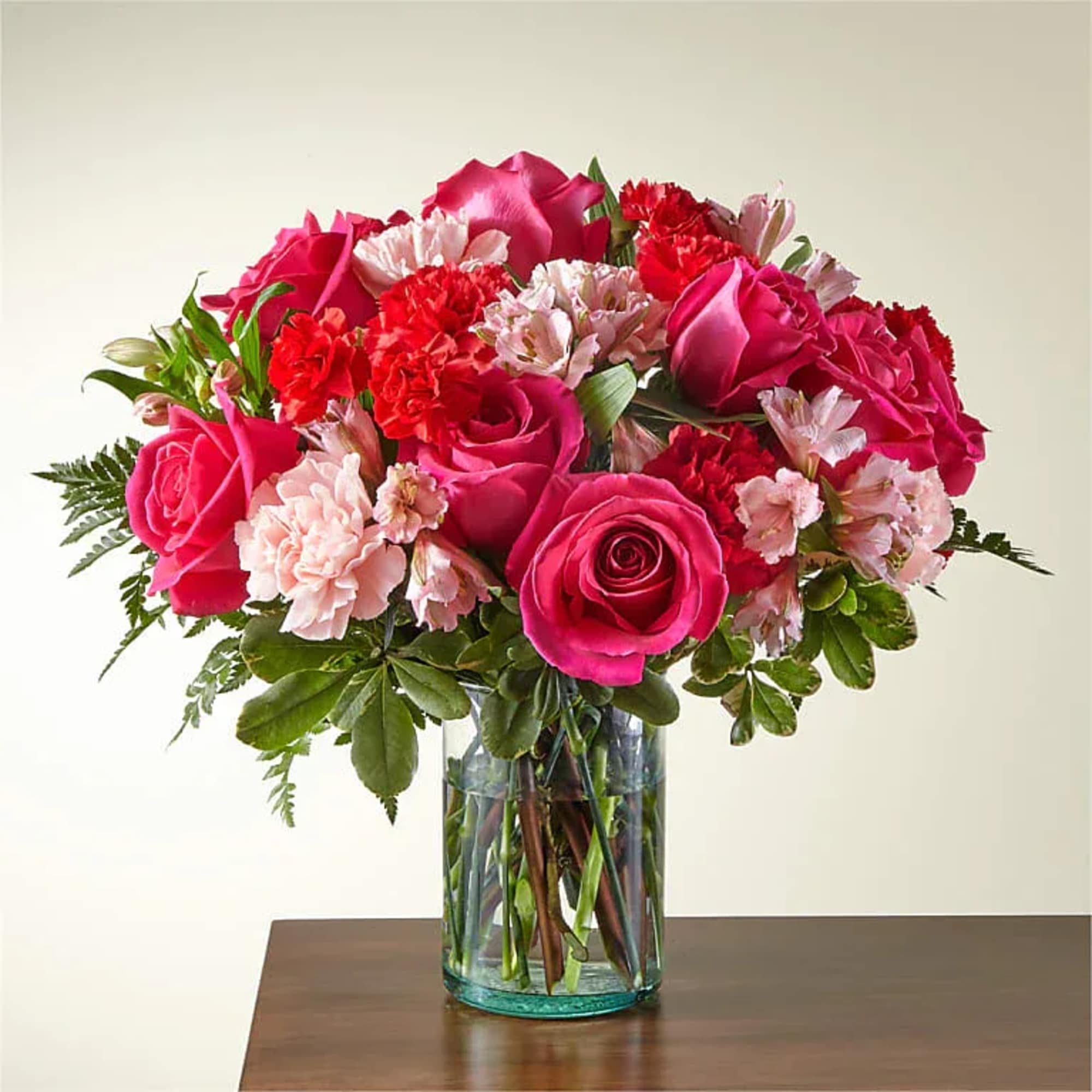 Blushing shades of pink blooms are nestled in lush greens to charm