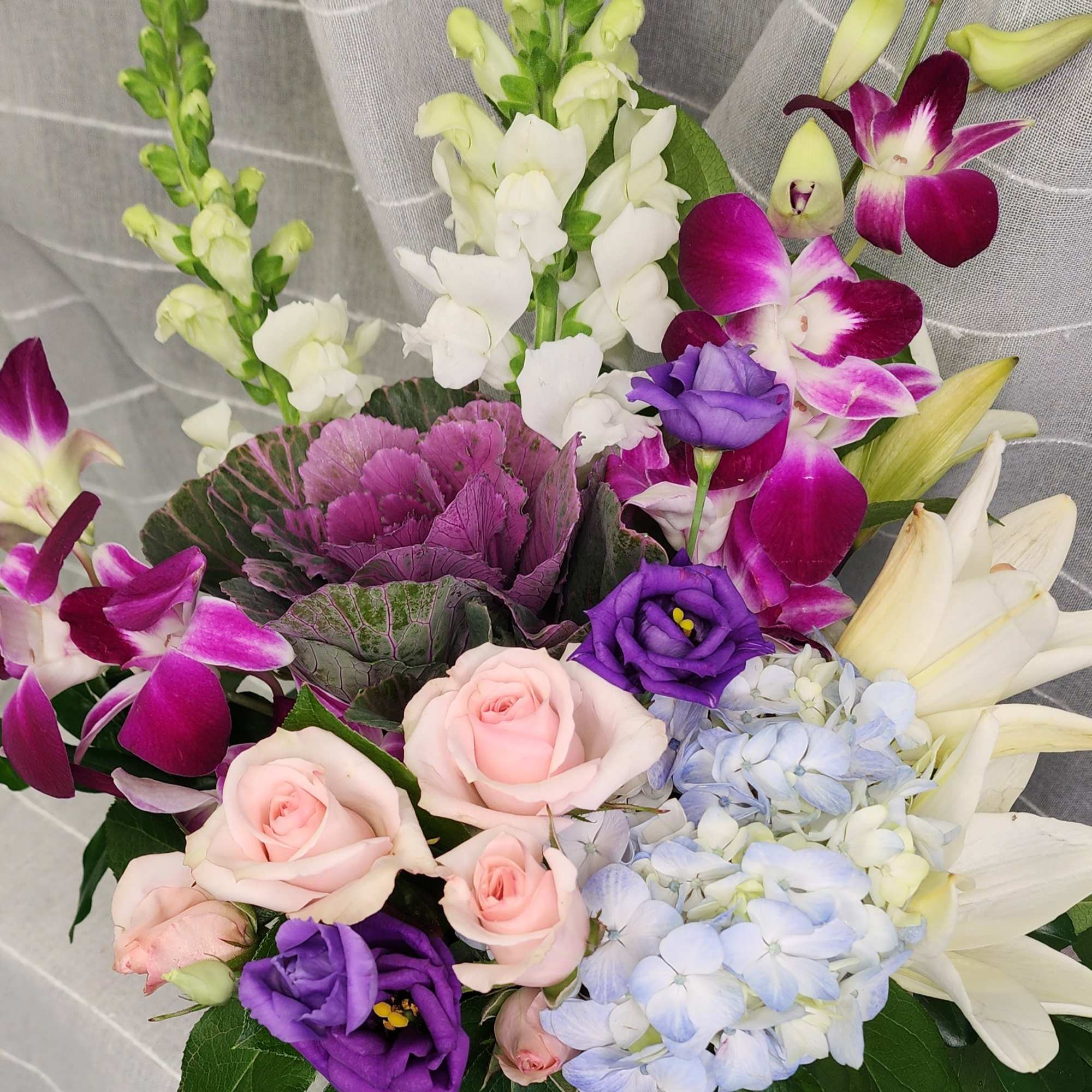 A beautiful array of dendrobium orchids, lilies, spray roses,  lisianthus, snapdragons