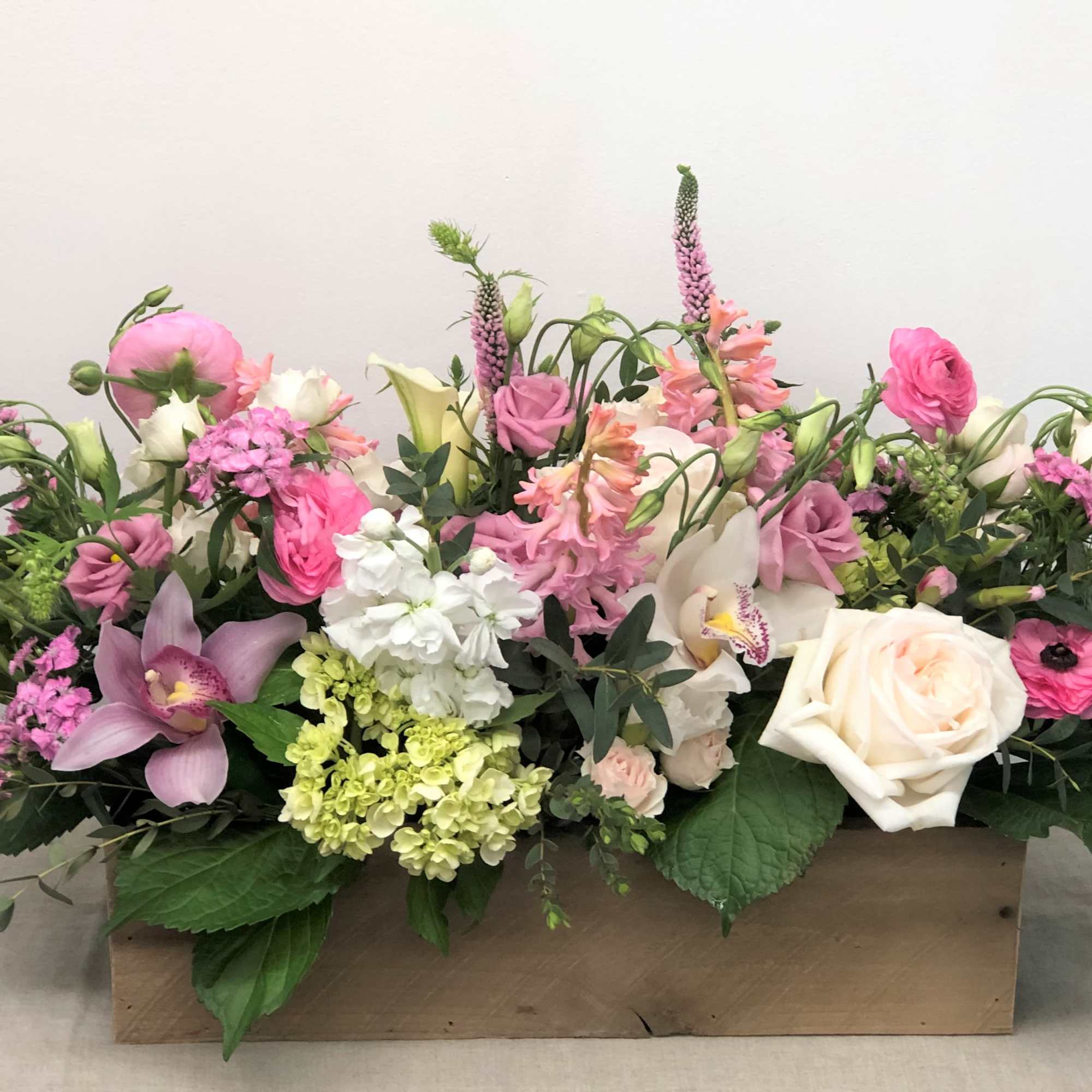 An extravagant arrangement of dazzling flowers in a large oblong planter box.