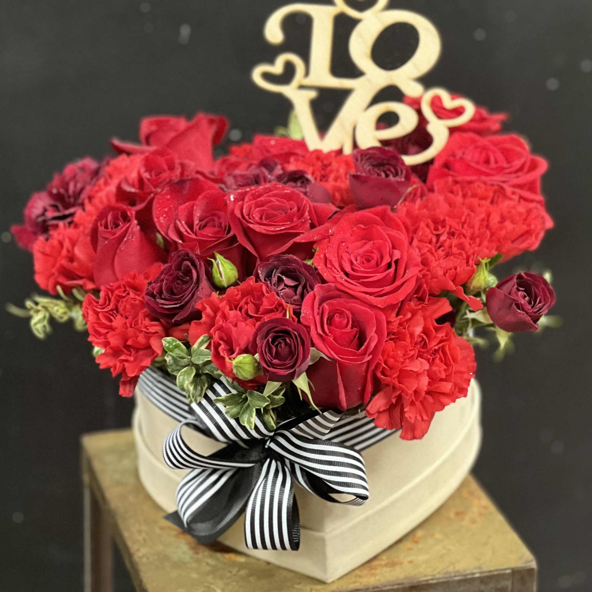 Simply adorable, red flowers, arranged in headbox decorated with romantic ribbon tied