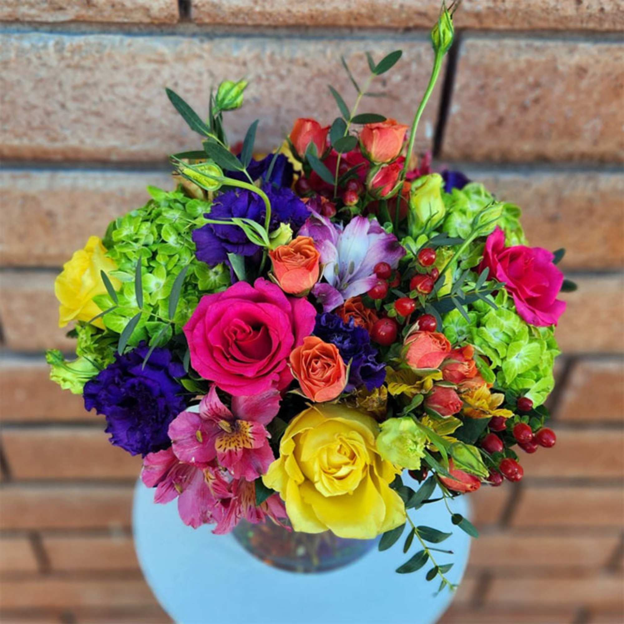 Our vivid bouquet features roses, hydrangea, lisianthus, alstroemerias, hypericum berries, eucalyptus and