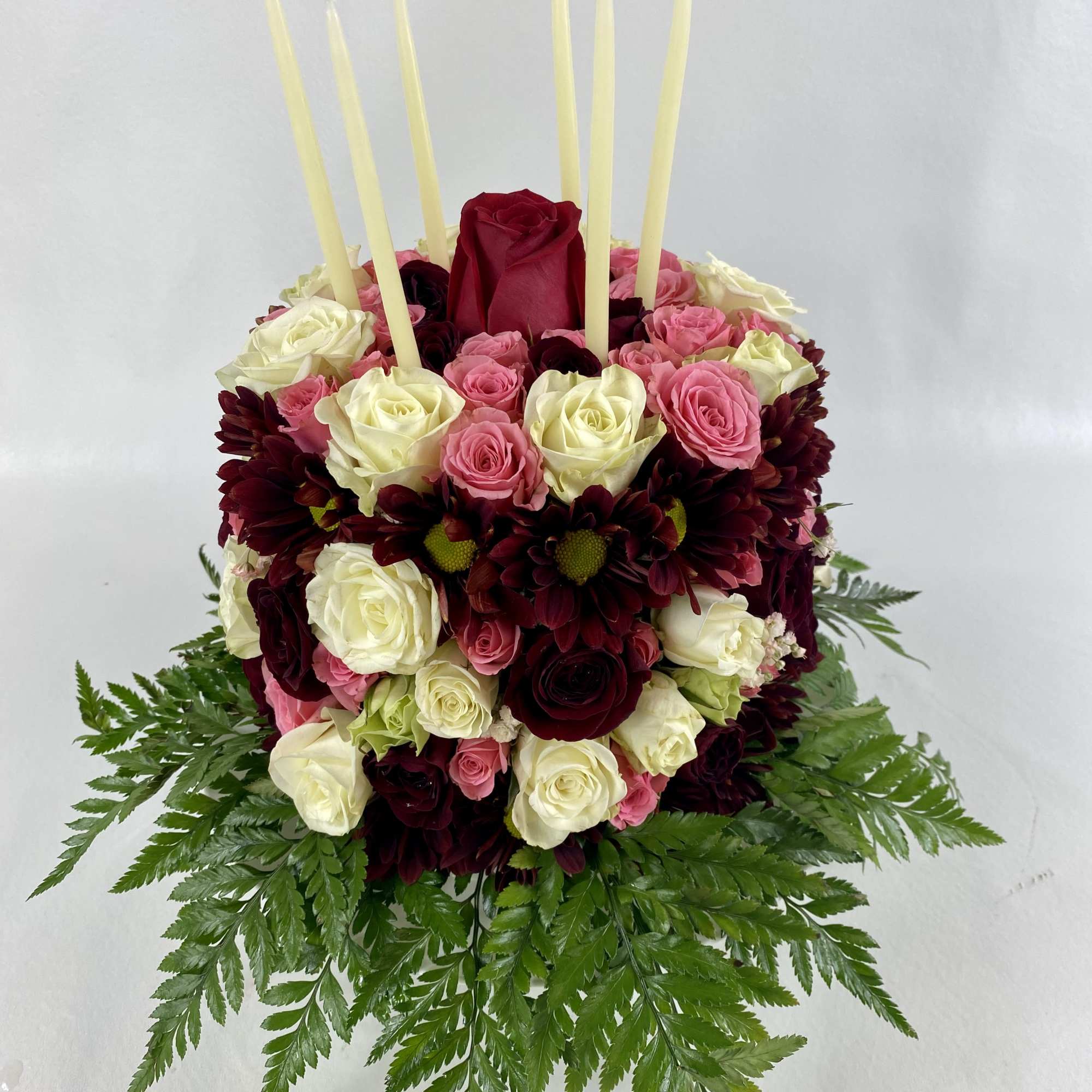 Rich flower cake on a stand contains pink and red spray roses