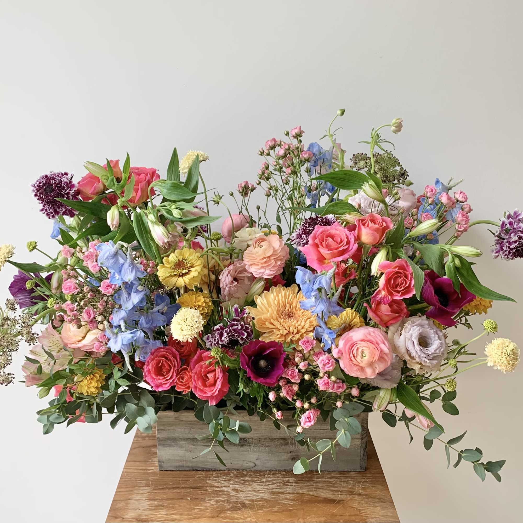 Lush flower arrangement in a 12 inch long wooden planter box with