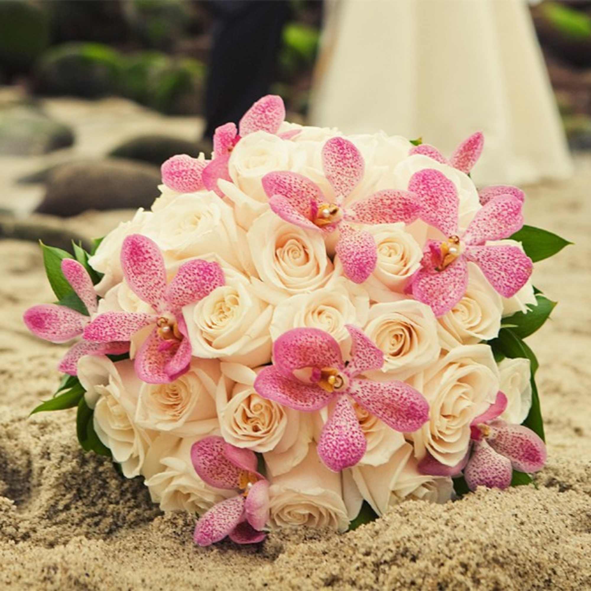 Classic Roses dressed with blooms of exotic Mokara Orchids, make up this