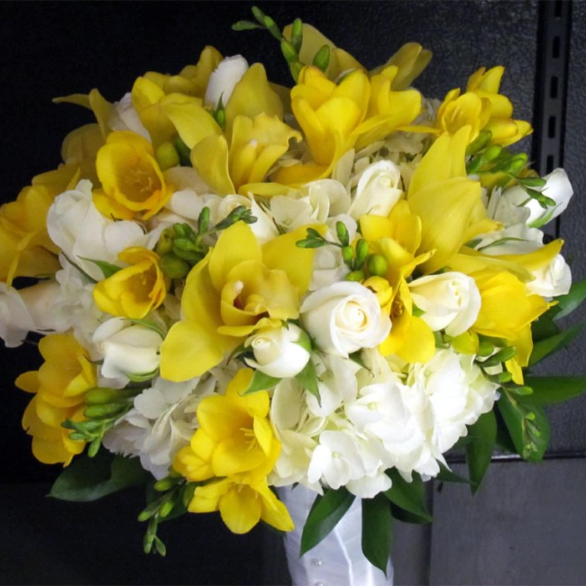 This premium bridal bouquet features White Hydrangeas, White Spray Roses, Yellow Cymbidium