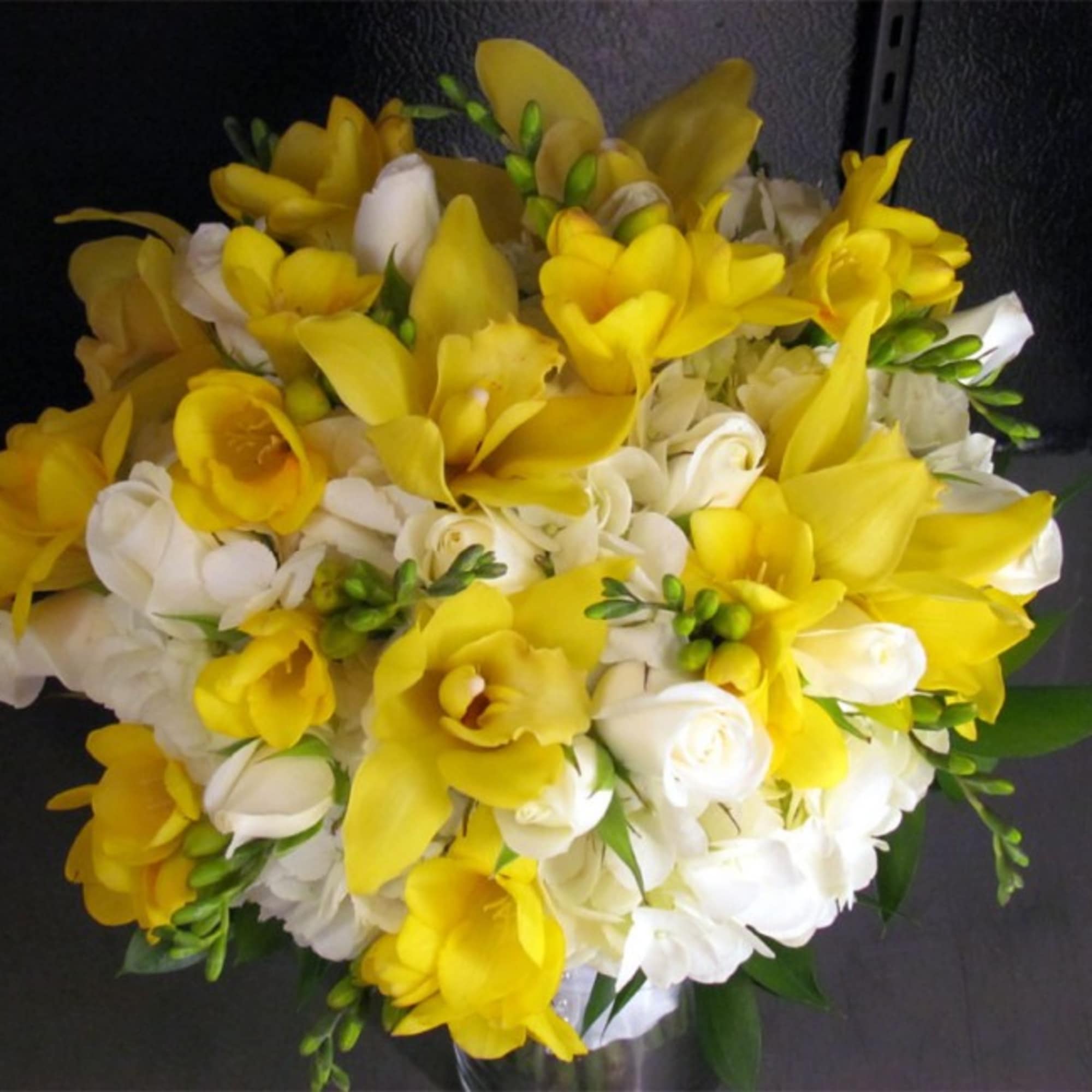 This premium bridal bouquet features White Hydrangeas, White Spray Roses, Yellow Cymbidium