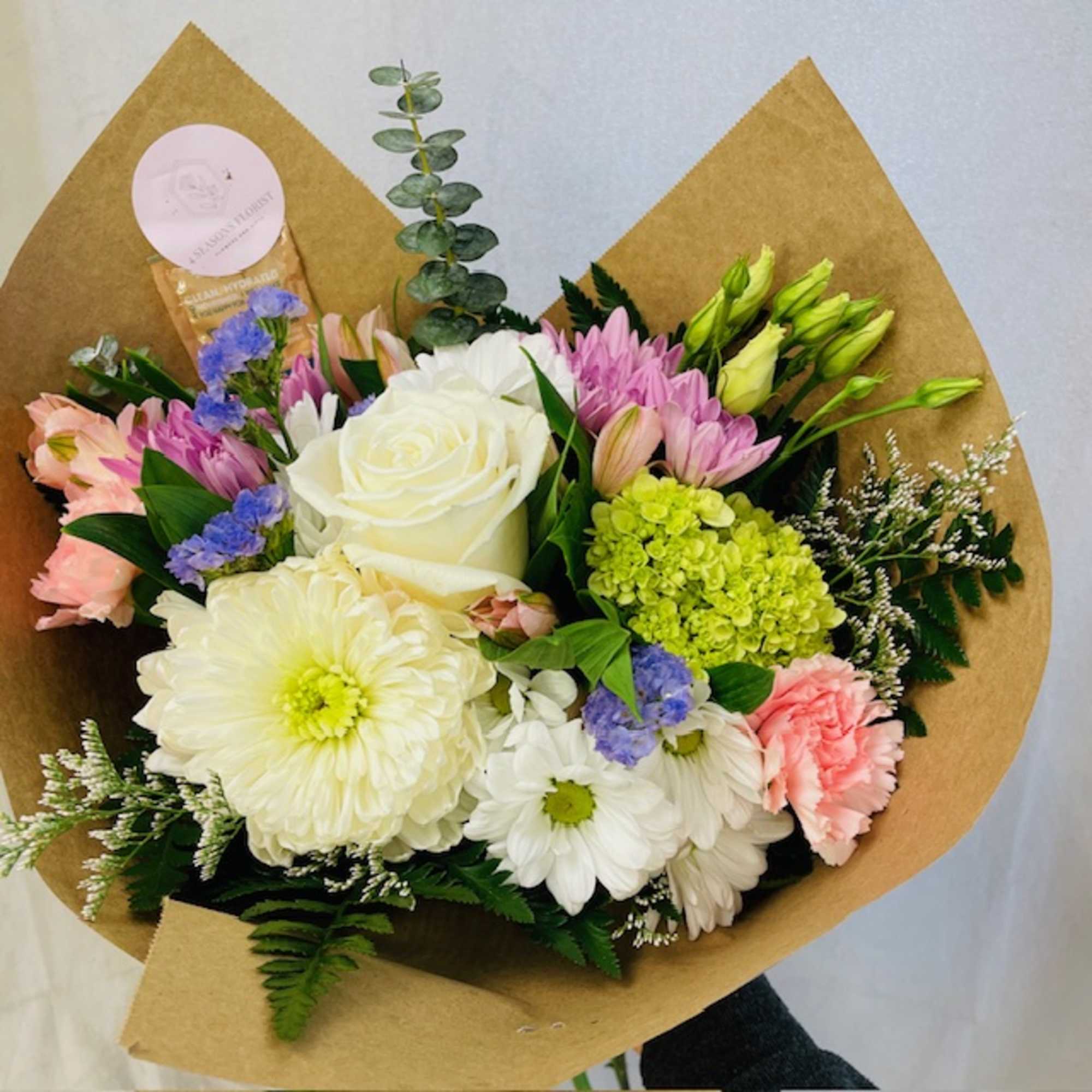 A selection of pastel flowers. This bouquet comes wrapped in paper, ready