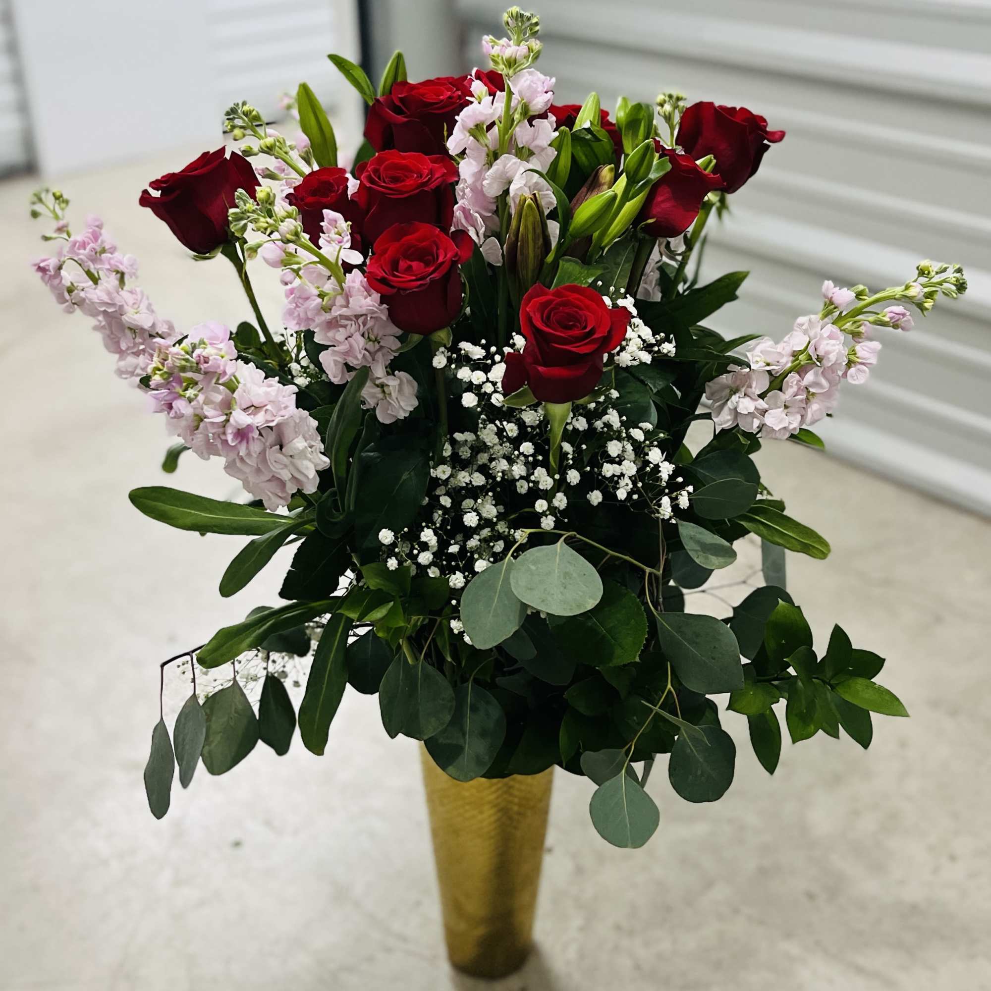 1 dozen roses with baby breathe in a gold vase, eucalyptus ruscus