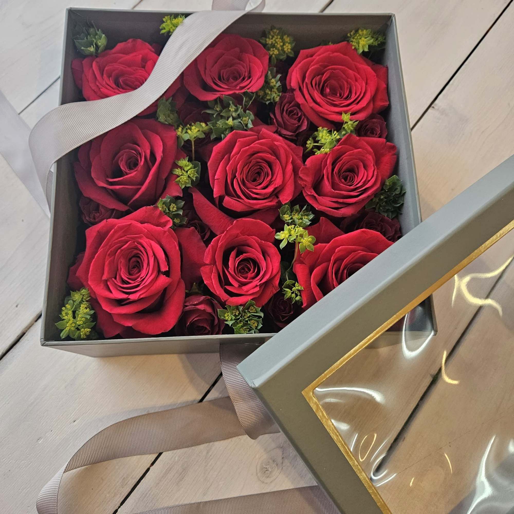 Low lush roses nestled beautifully in a soft gray peak-a-boo box. Its Low lush roses nestled beautifully in a soft gray peak-a-boo box. Its