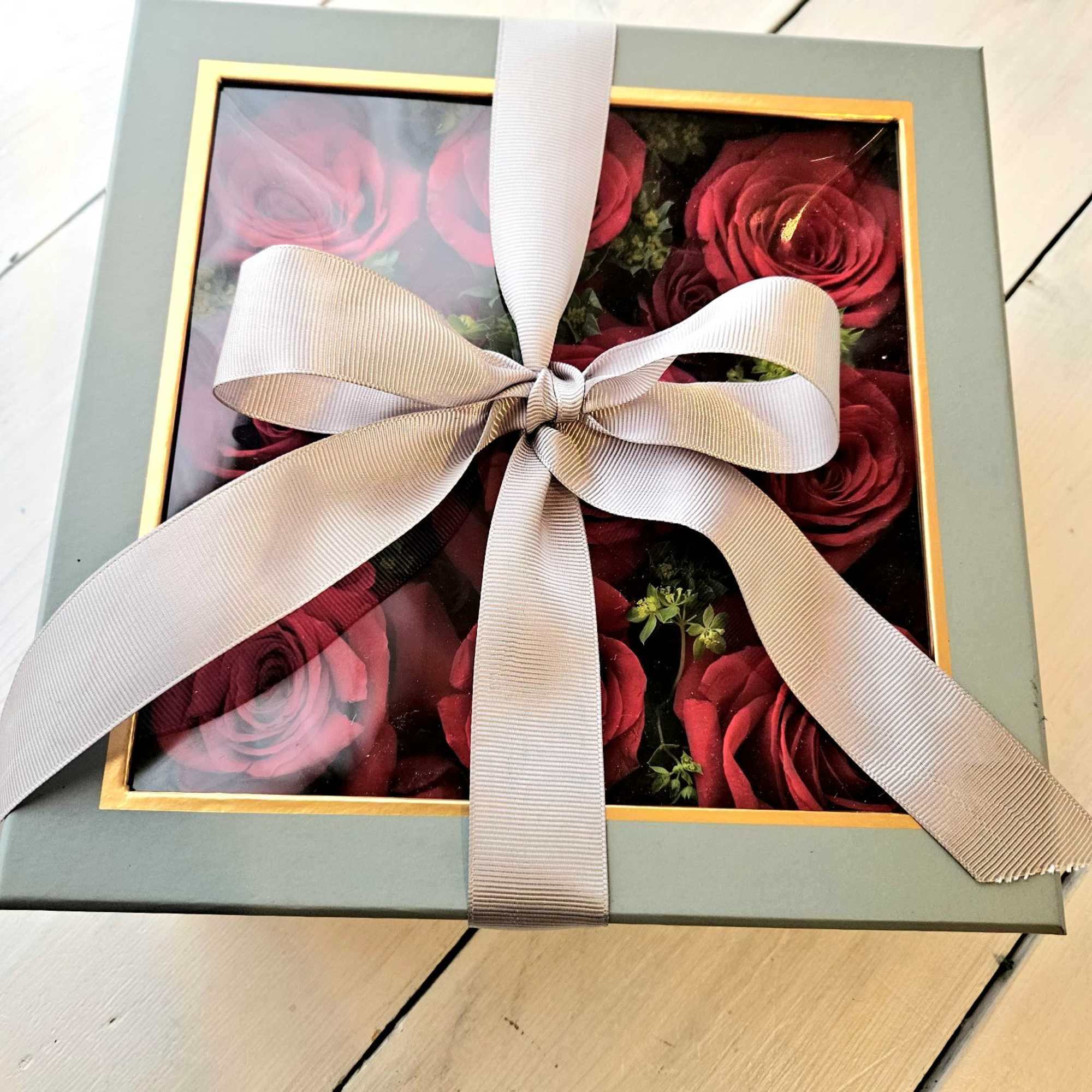 Low lush roses nestled beautifully in a soft gray peak-a-boo box. Its Low lush roses nestled beautifully in a soft gray peak-a-boo box. Its