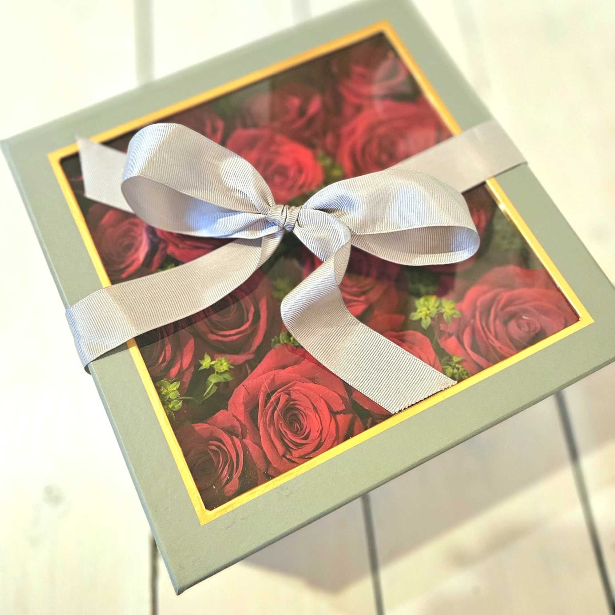 Low lush roses nestled beautifully in a soft gray peak-a-boo box. Its Low lush roses nestled beautifully in a soft gray peak-a-boo box. Its