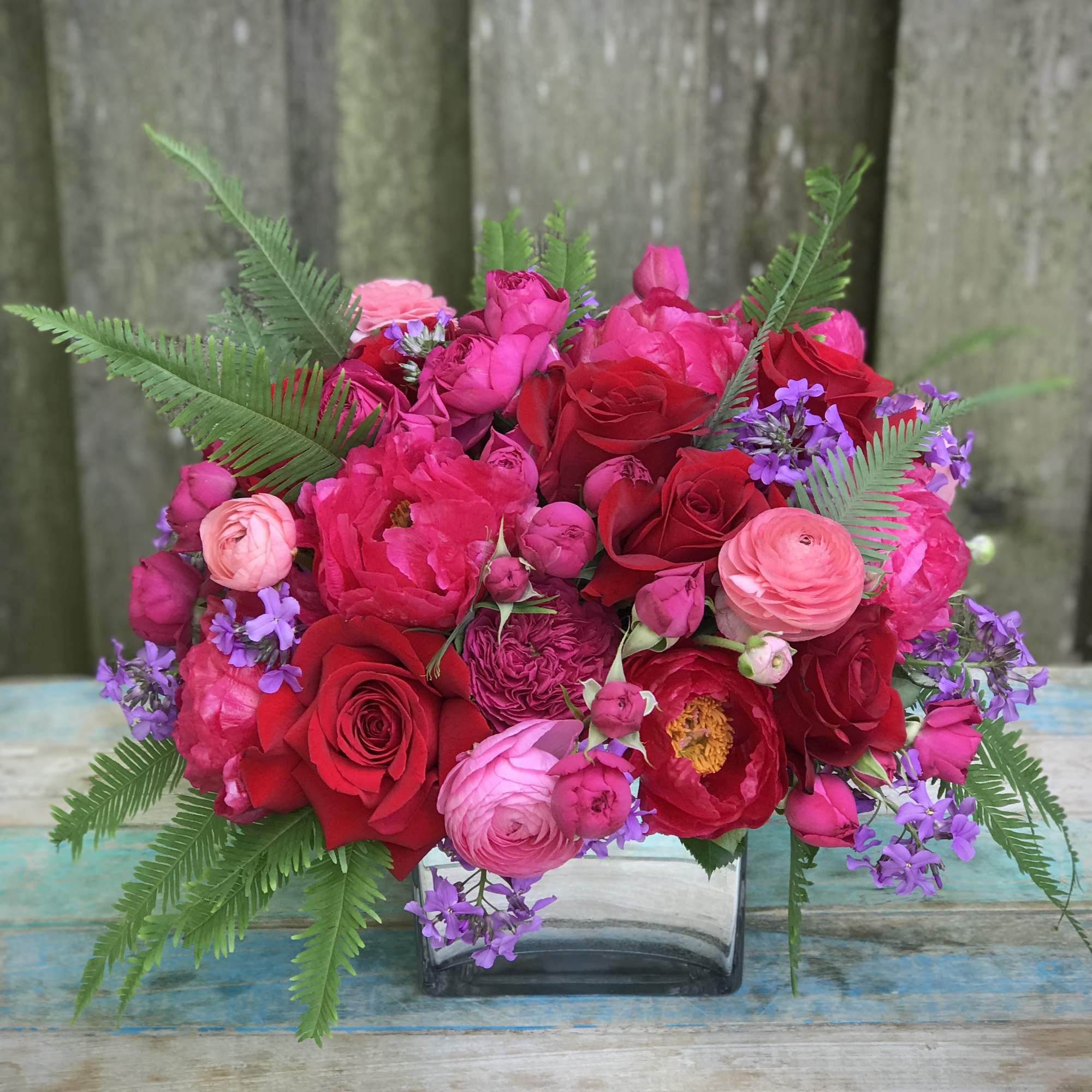 Romantic blossoms and colors gathered in a glamorous container to celebrate love.