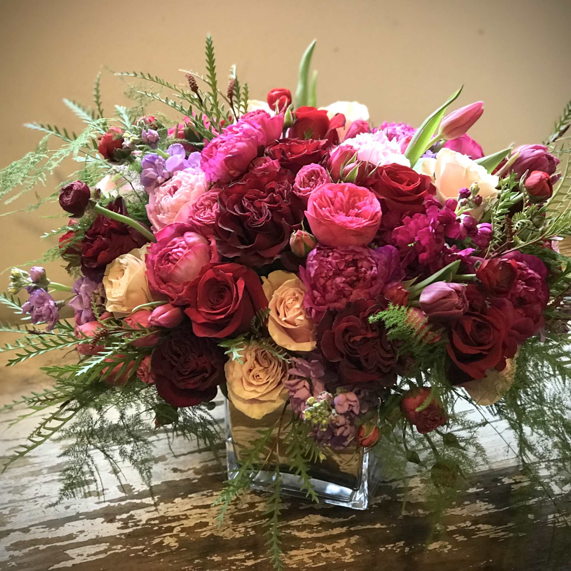 Romantic blossoms and colors gathered in a glamorous container to celebrate love.