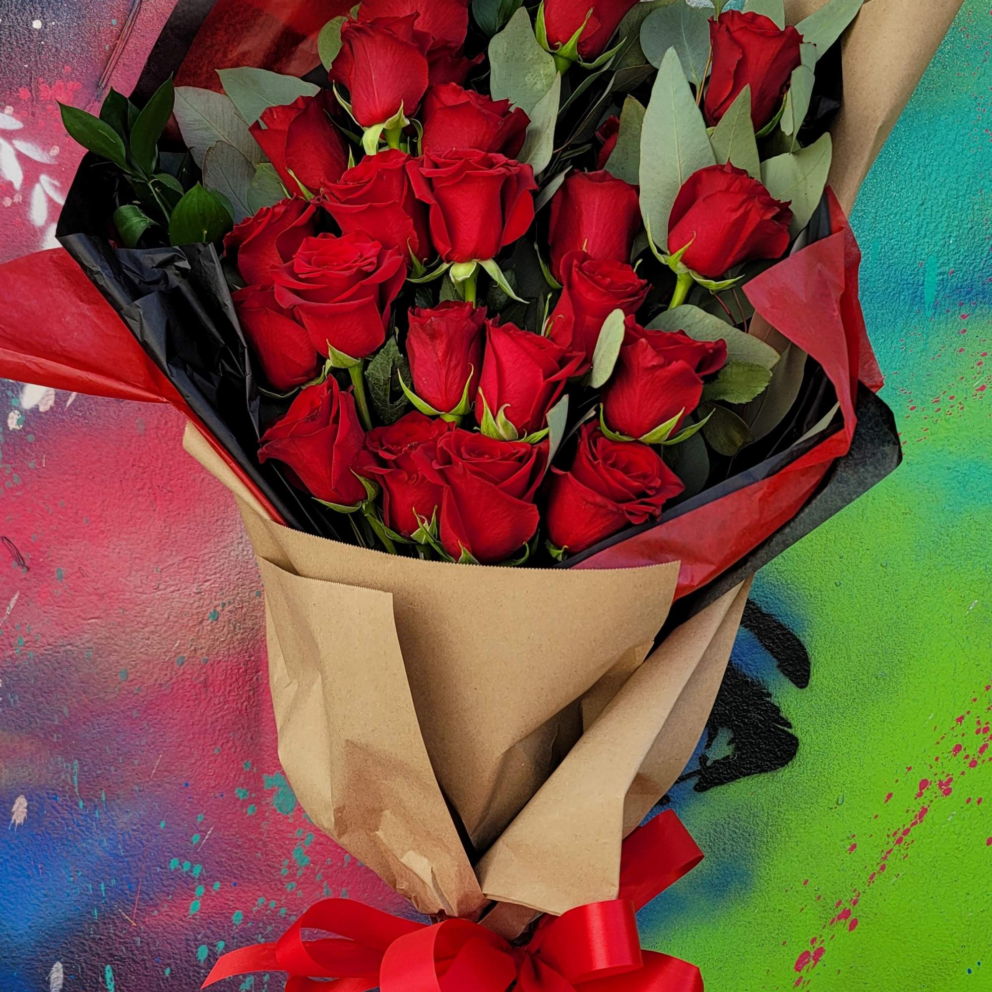 Bouquet of 18 roses with eucalyptus, greenery wrapped with craft paper, colored
