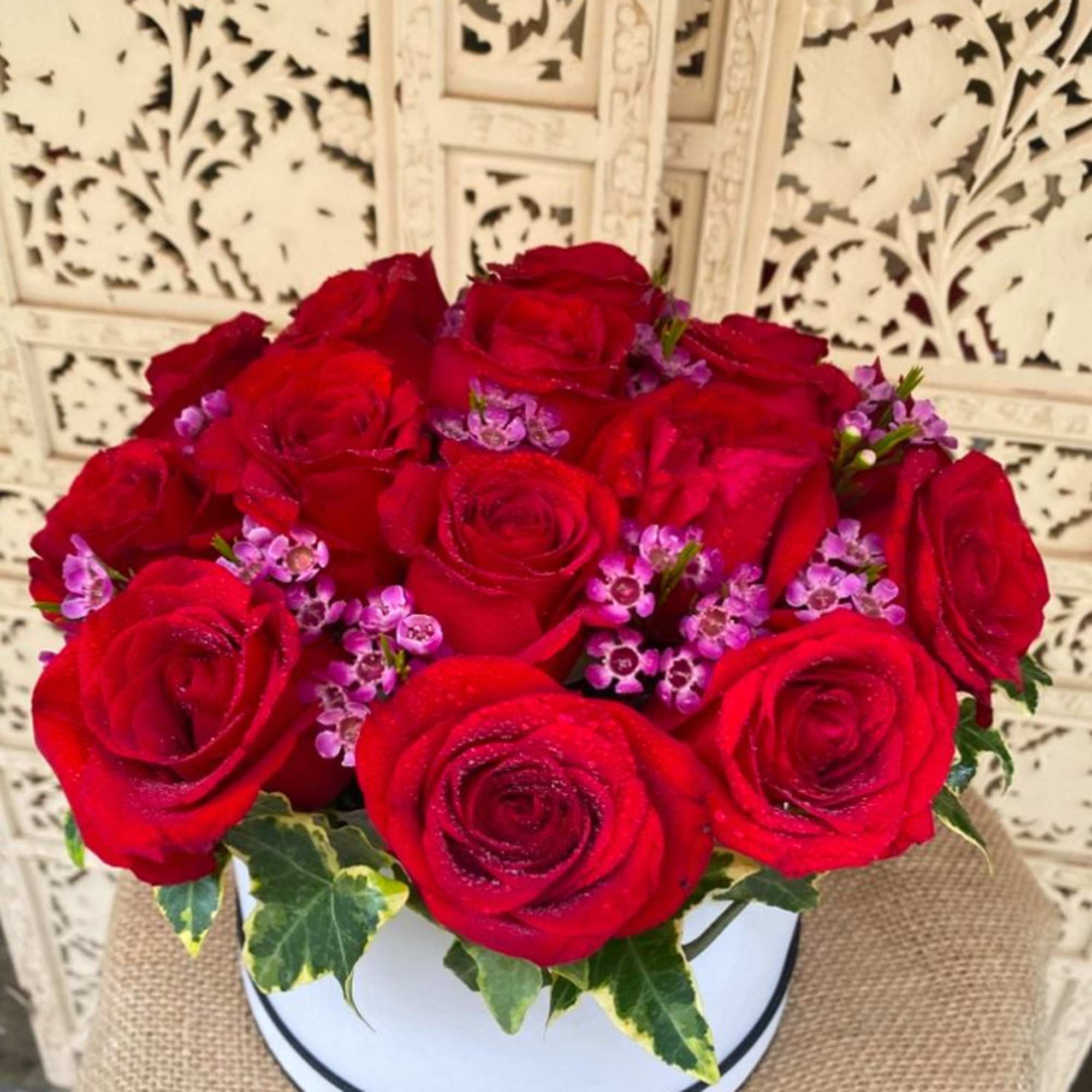 A dozen, big velvety roses in a round hat box. Finished off