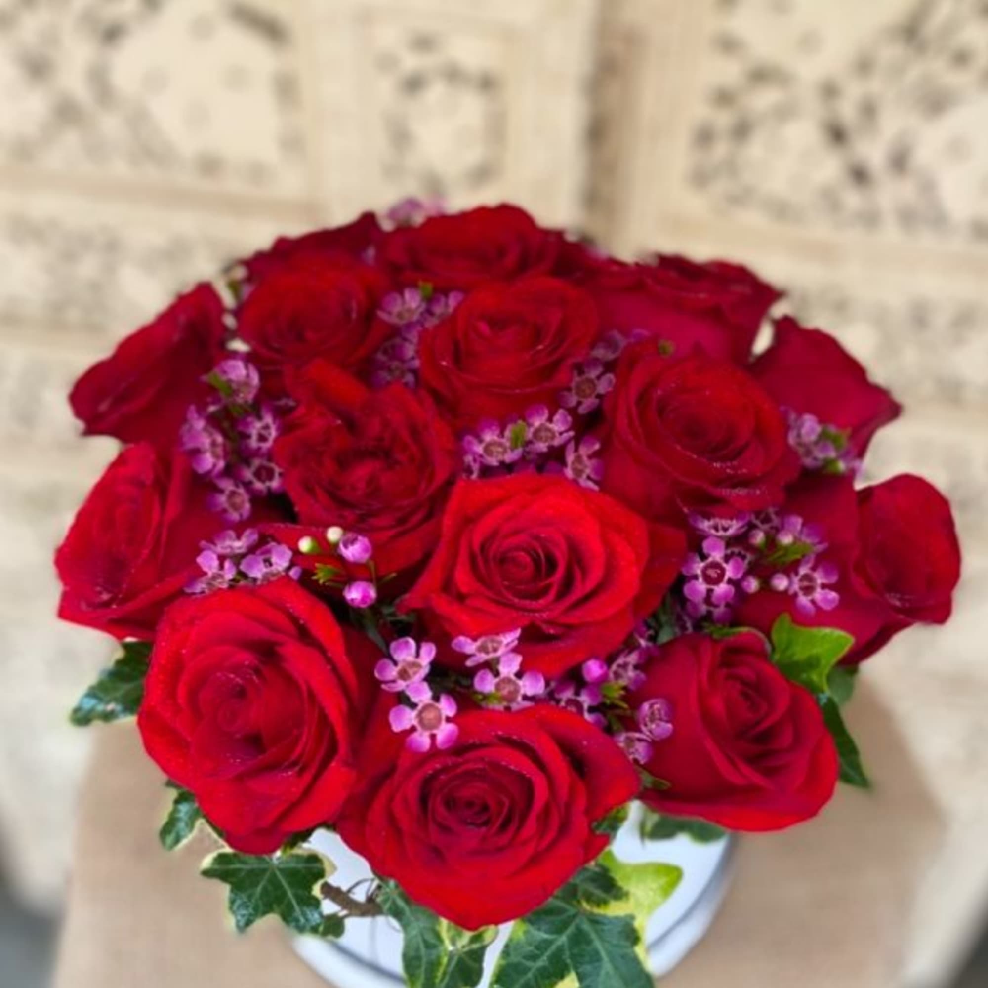 A dozen, big velvety roses in a round hat box. Finished off