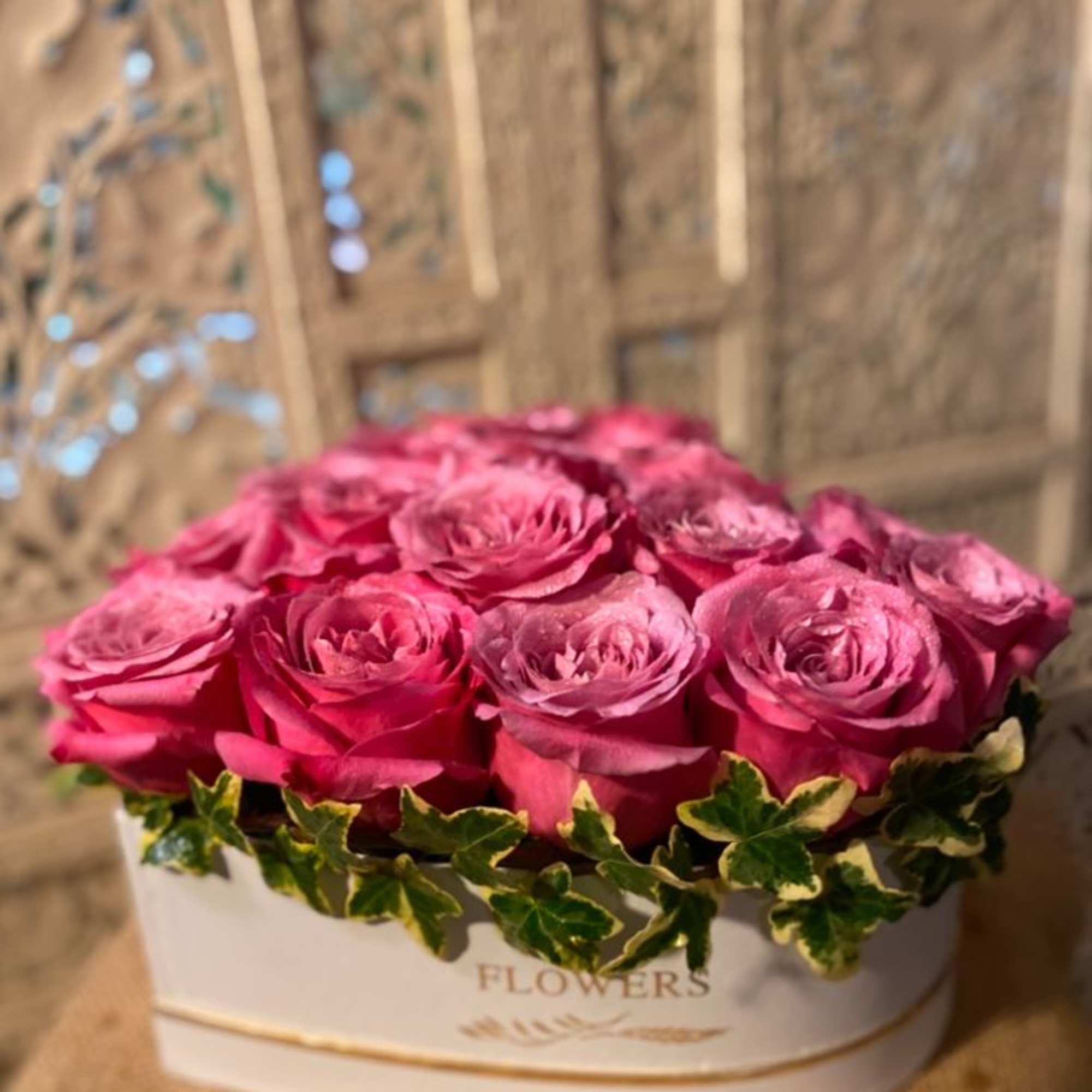 Big, beautiful, roses in a heart shaped box. Accent of garden ivy.