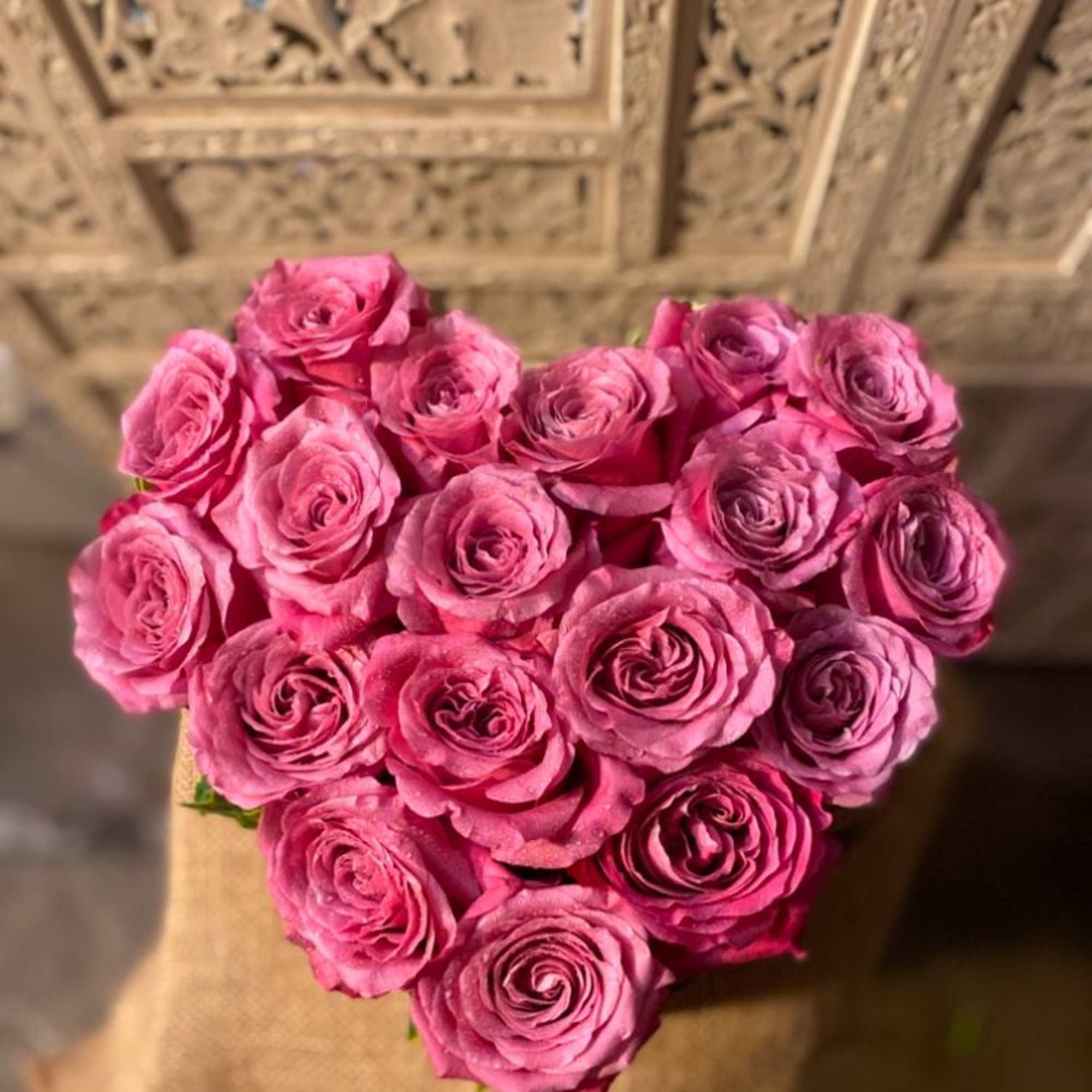 Big, beautiful, roses in a heart shaped box. Accent of garden ivy.