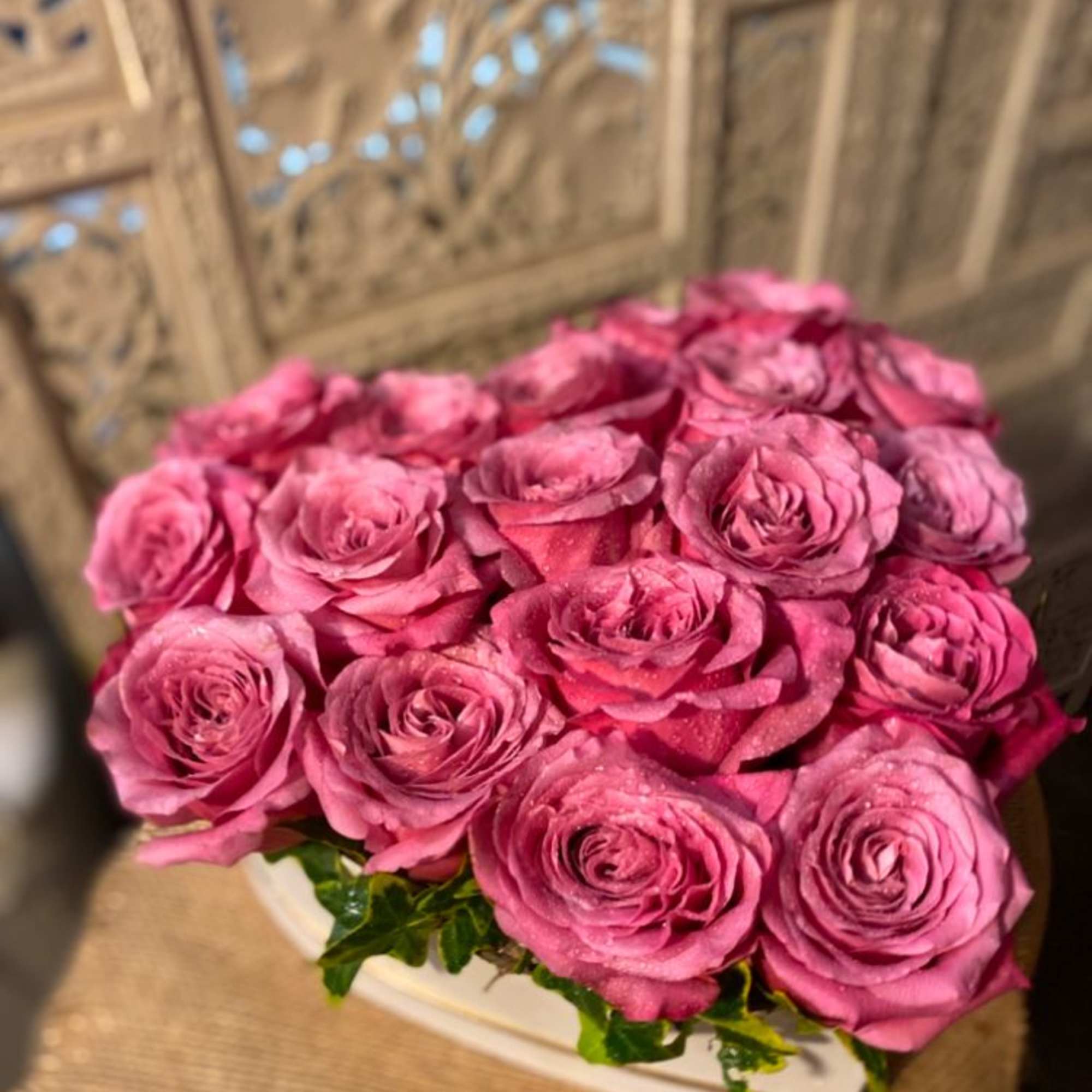 Big, beautiful, roses in a heart shaped box. Accent of garden ivy.