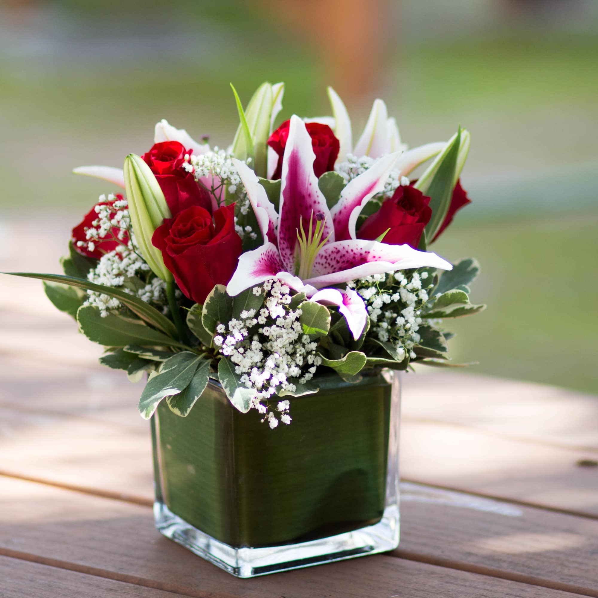 - 6 Freedom Roses
- 3 Pink Lilies
- Baby Breath
- Seasonal Greens - 6 Freedom Roses
- 3 Pink Lilies
- Baby Breath
- Seasonal Greens