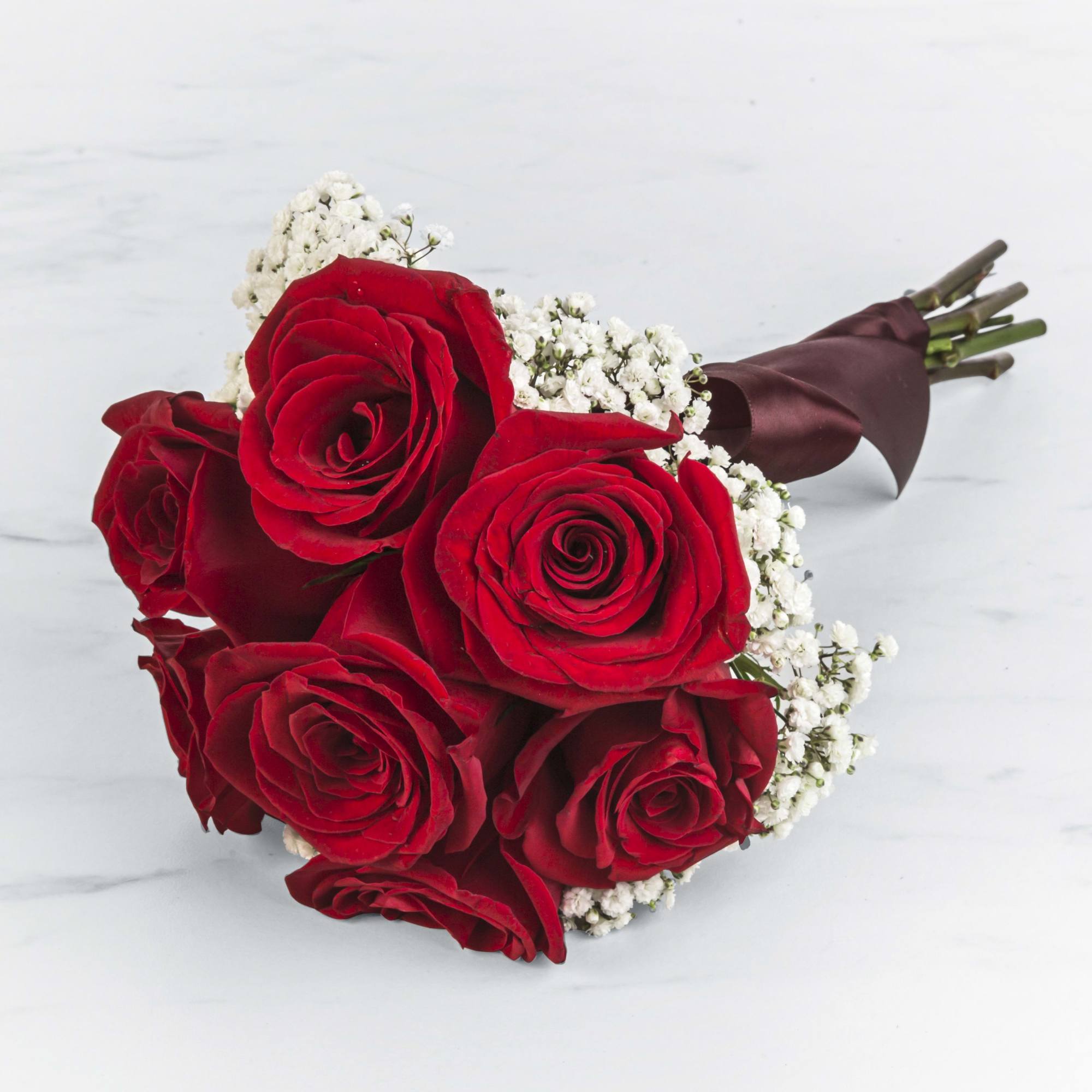 A classic rose and baby&#039;s breath bouquet hand tied with ribbon. The