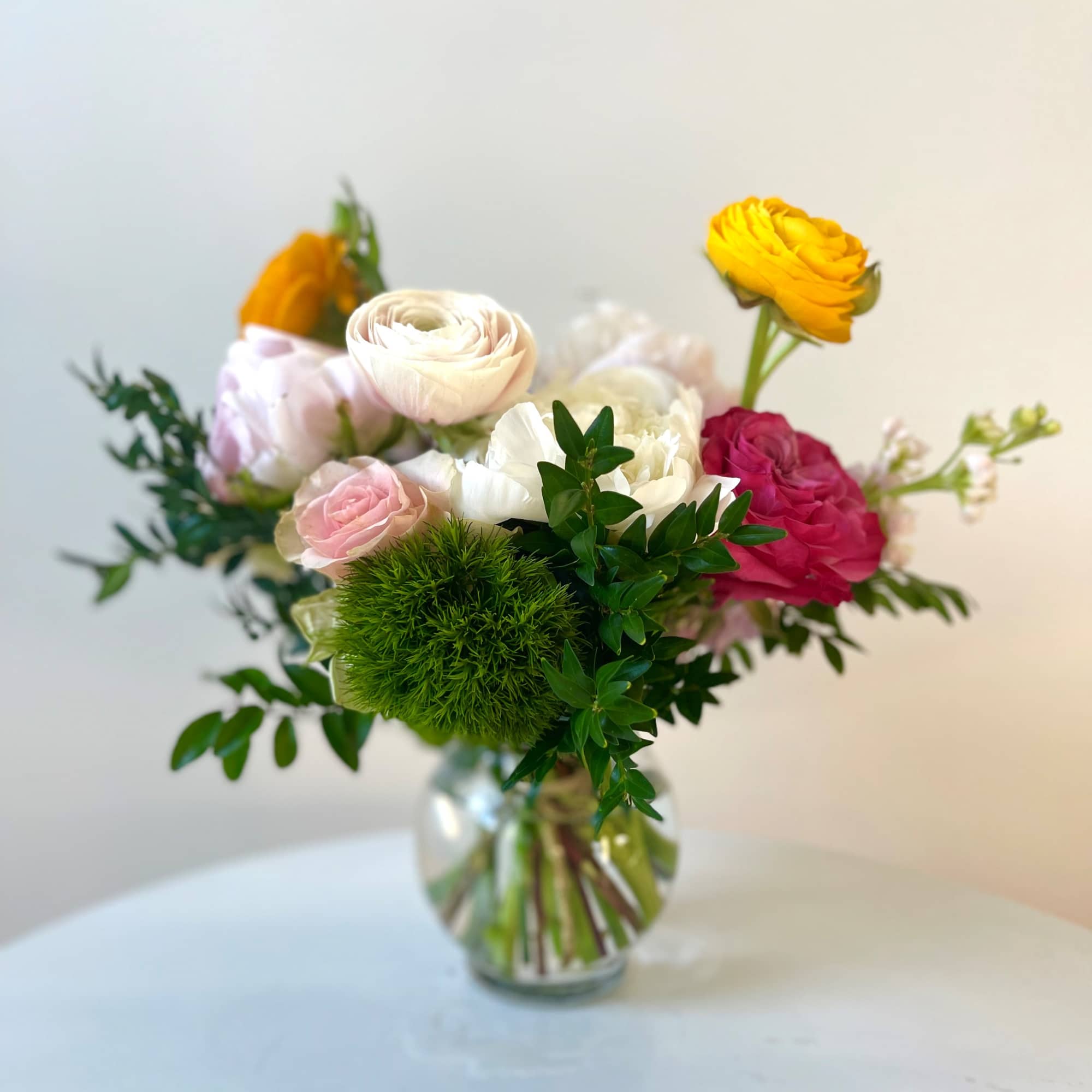 This perfect fishbowl filled with ranunculus, peonies and roses is a great