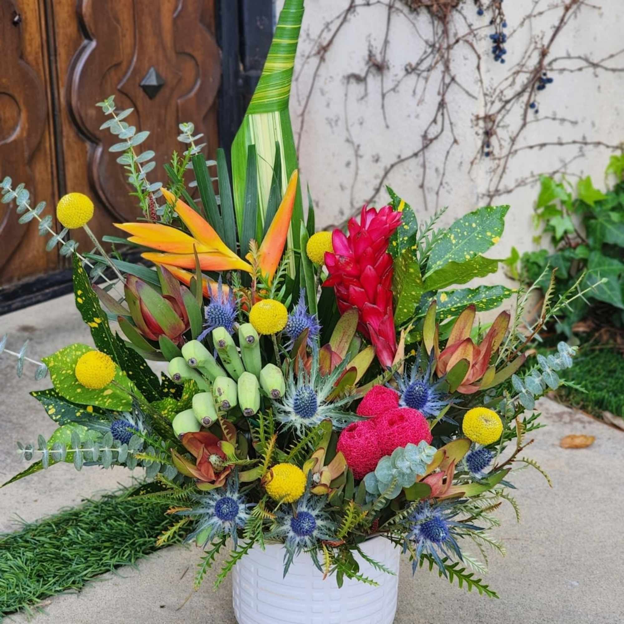 This vibrant tropical arrangement features an exotic mix of bold colors and