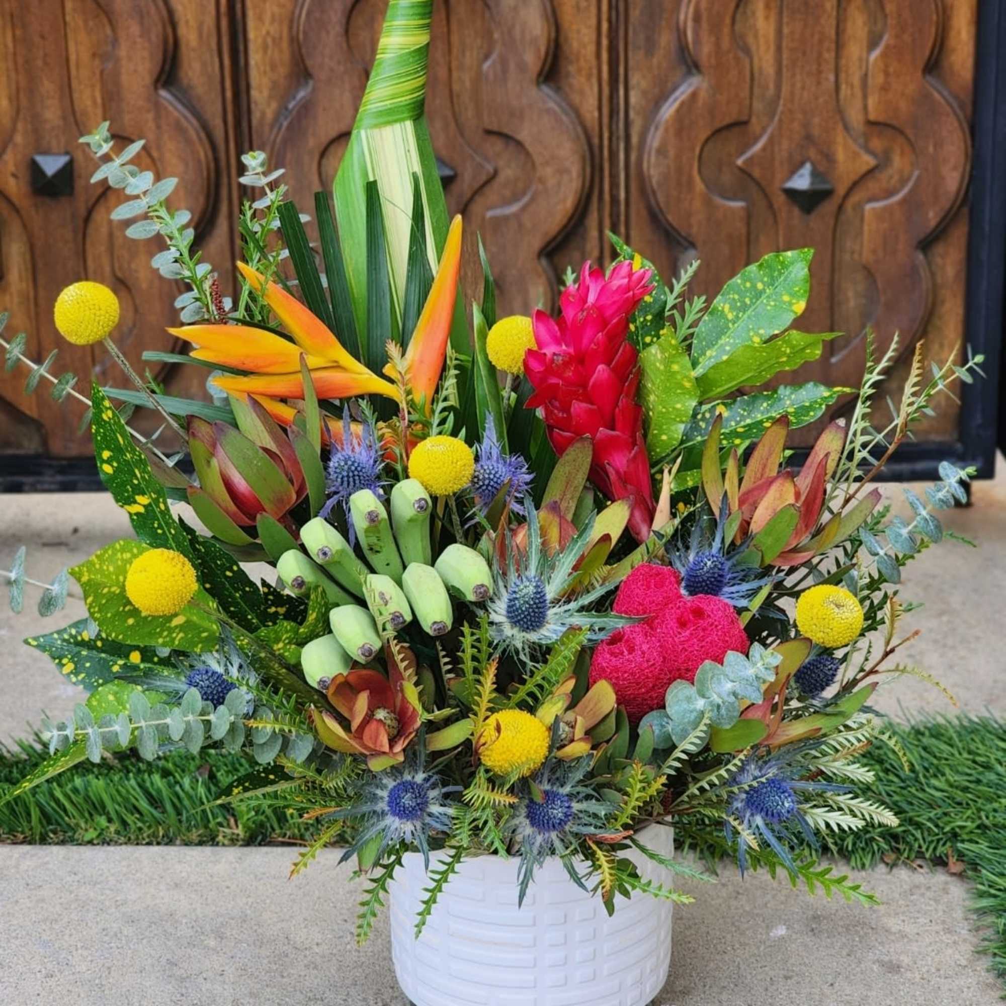 This vibrant tropical arrangement features an exotic mix of bold colors and