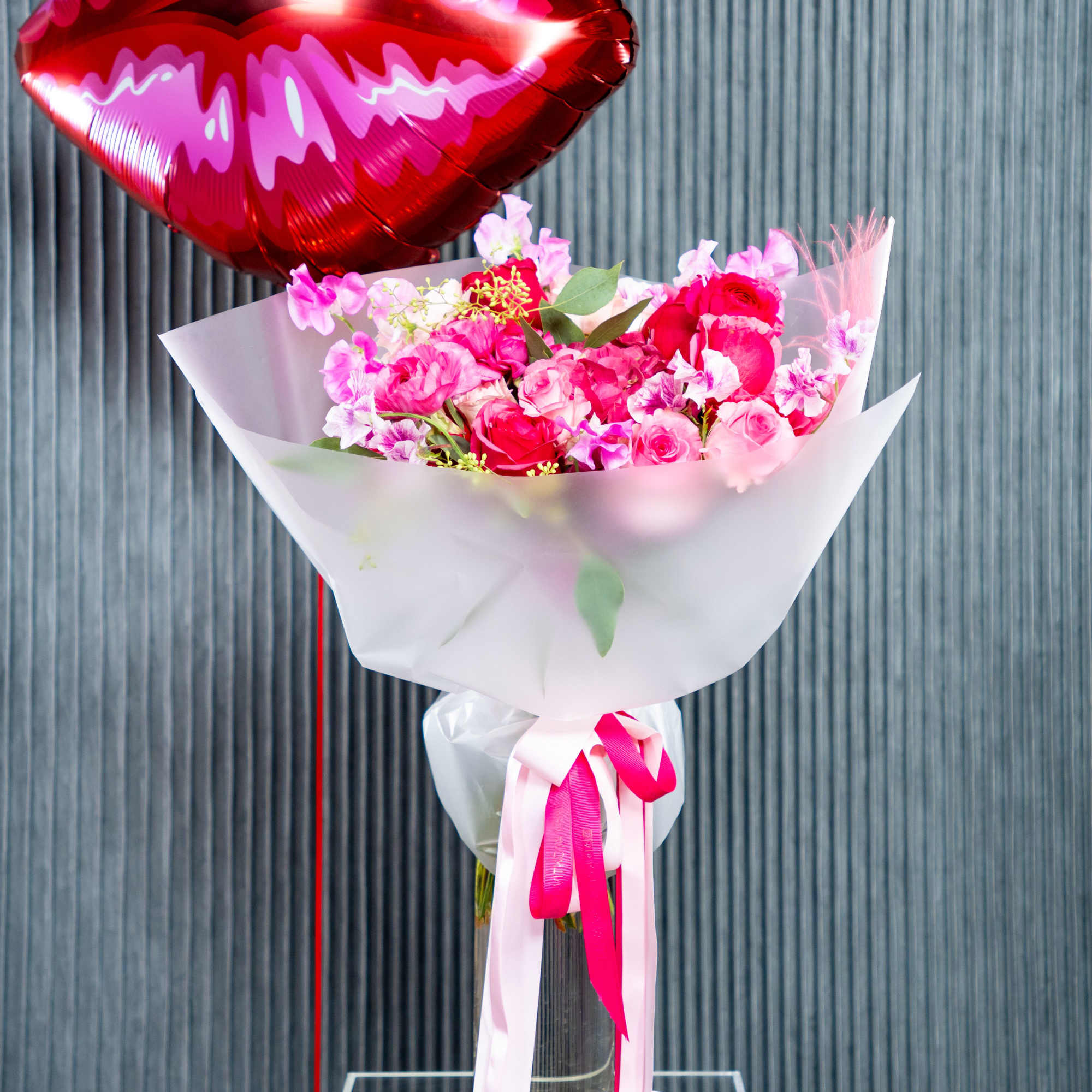 A delicate and charming arrangement of pink roses and sweet blooms, wrapped