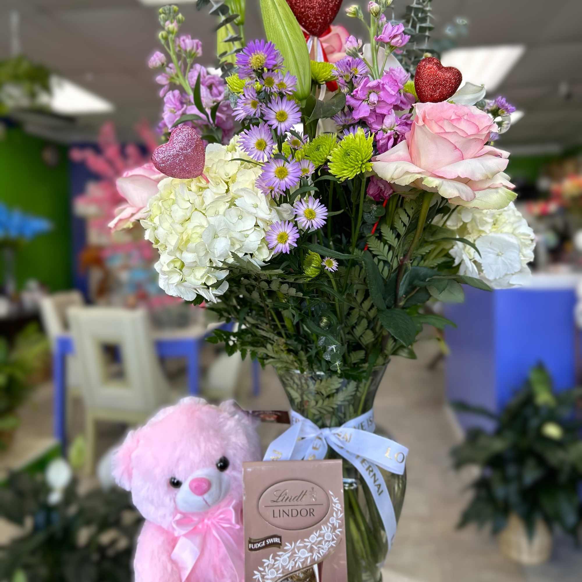 Makea day special with a beautiful flower arrangement and a soft teddy