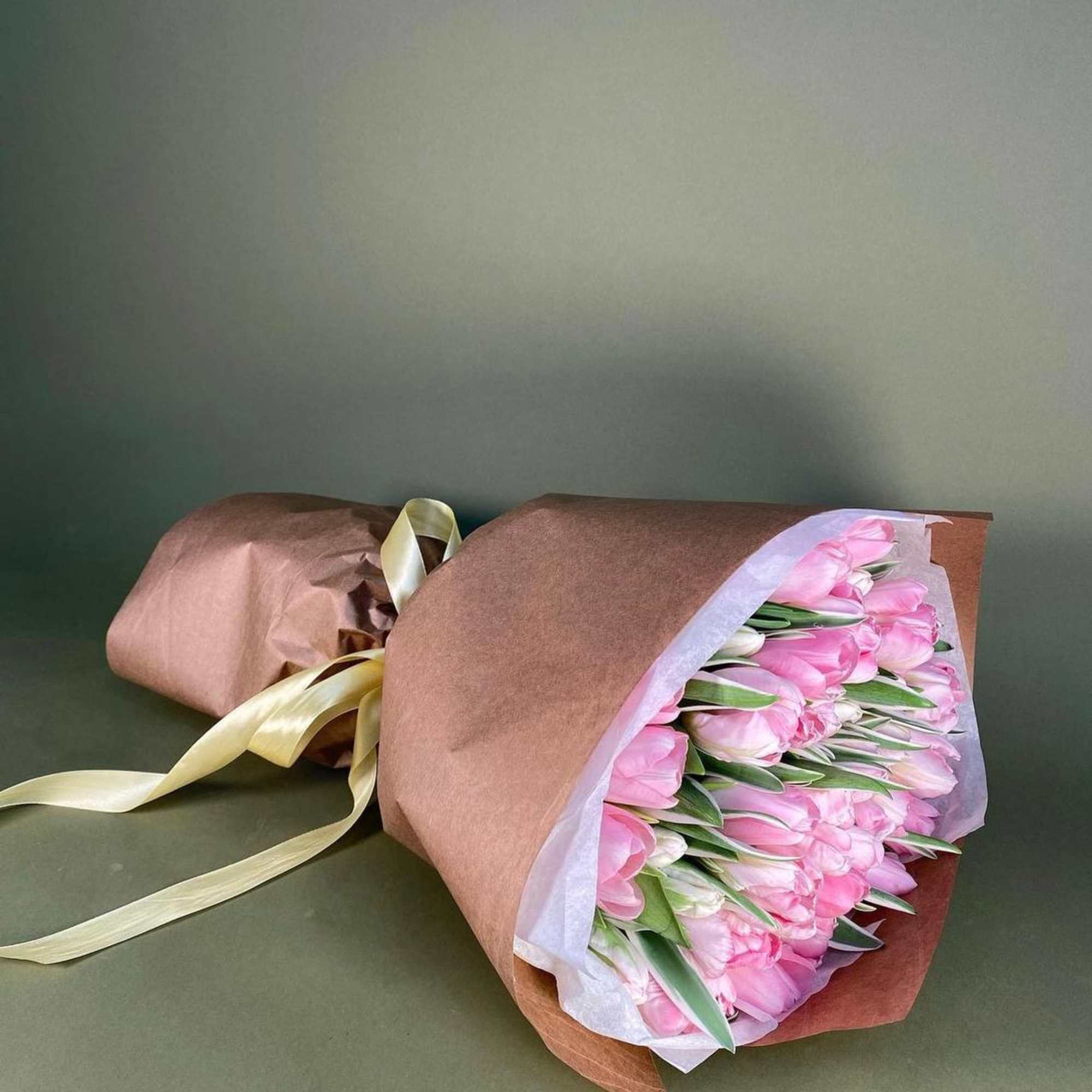 A bouquet of delicate pink tulips in craft paper is a stylish