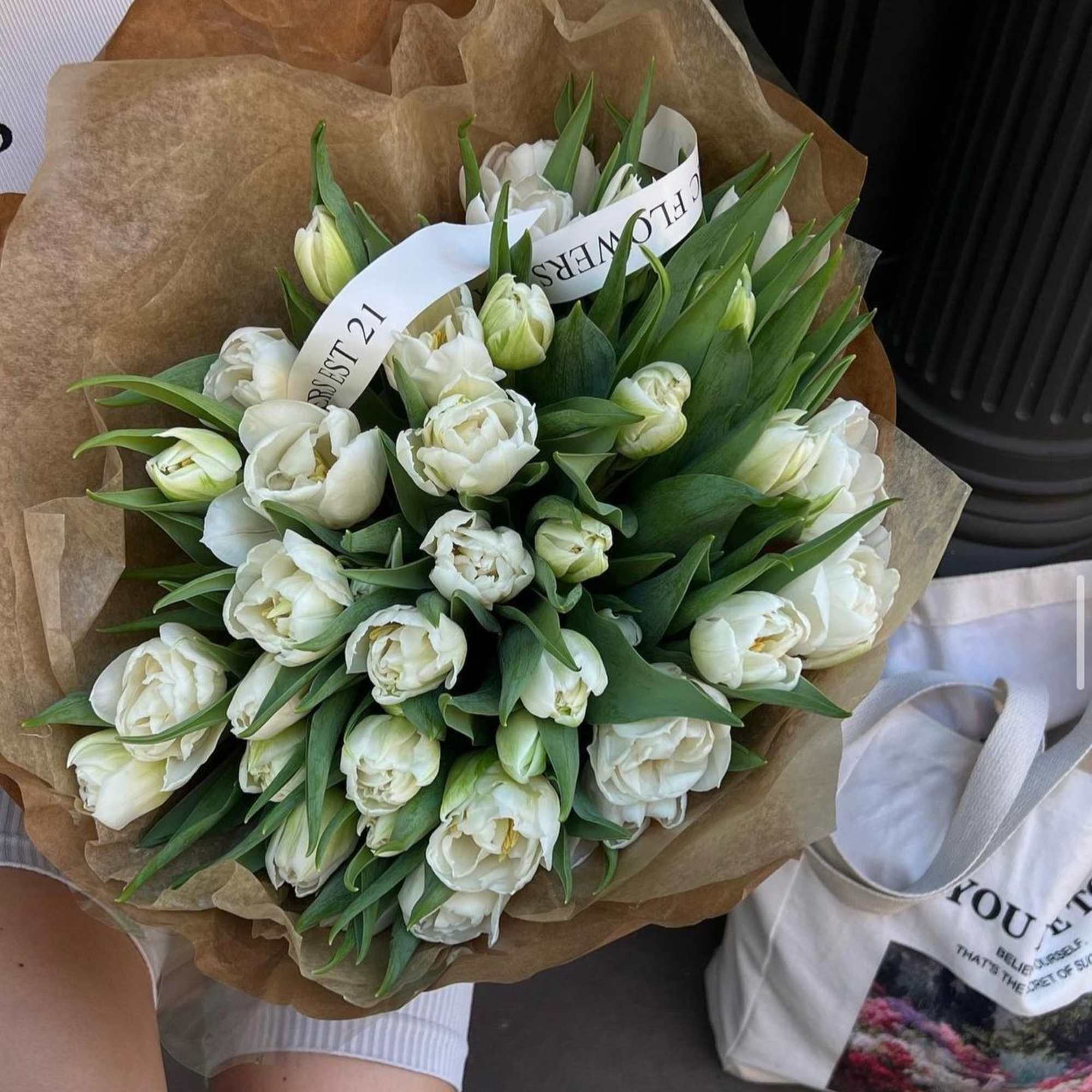 A bouquet of white tulips in kraft paper is an elegant and