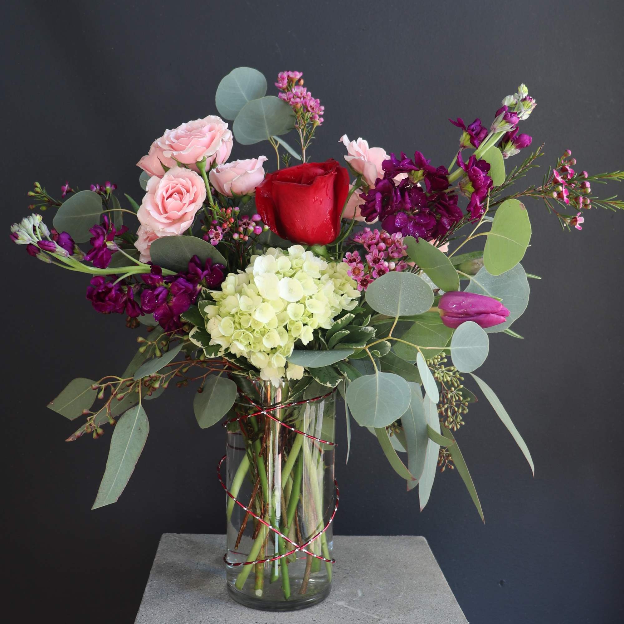 A beautiful arrangement of love with tulips, roses, hydrangea, and wax flowers