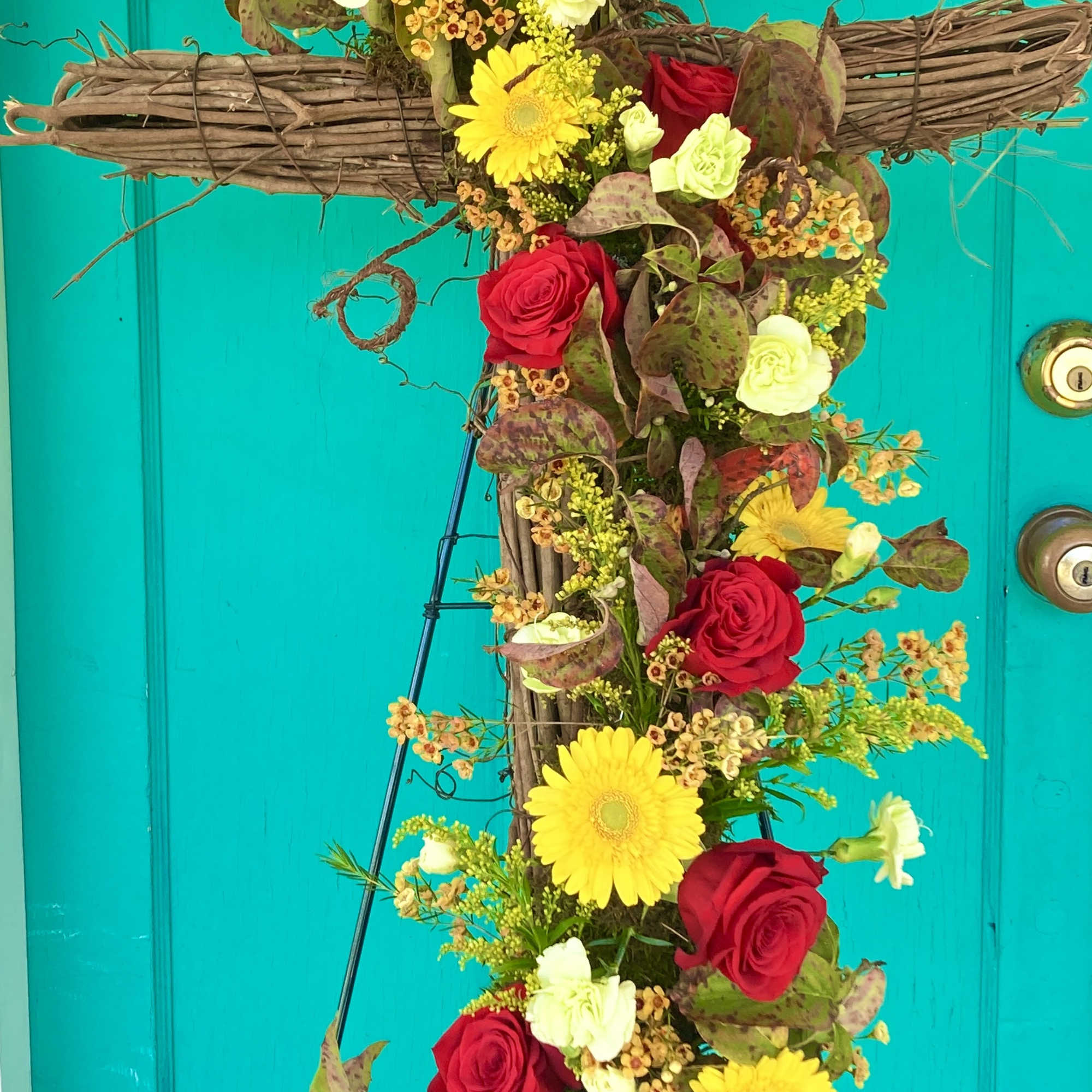 A beautiful standing spray using a grapevine cross as the base and