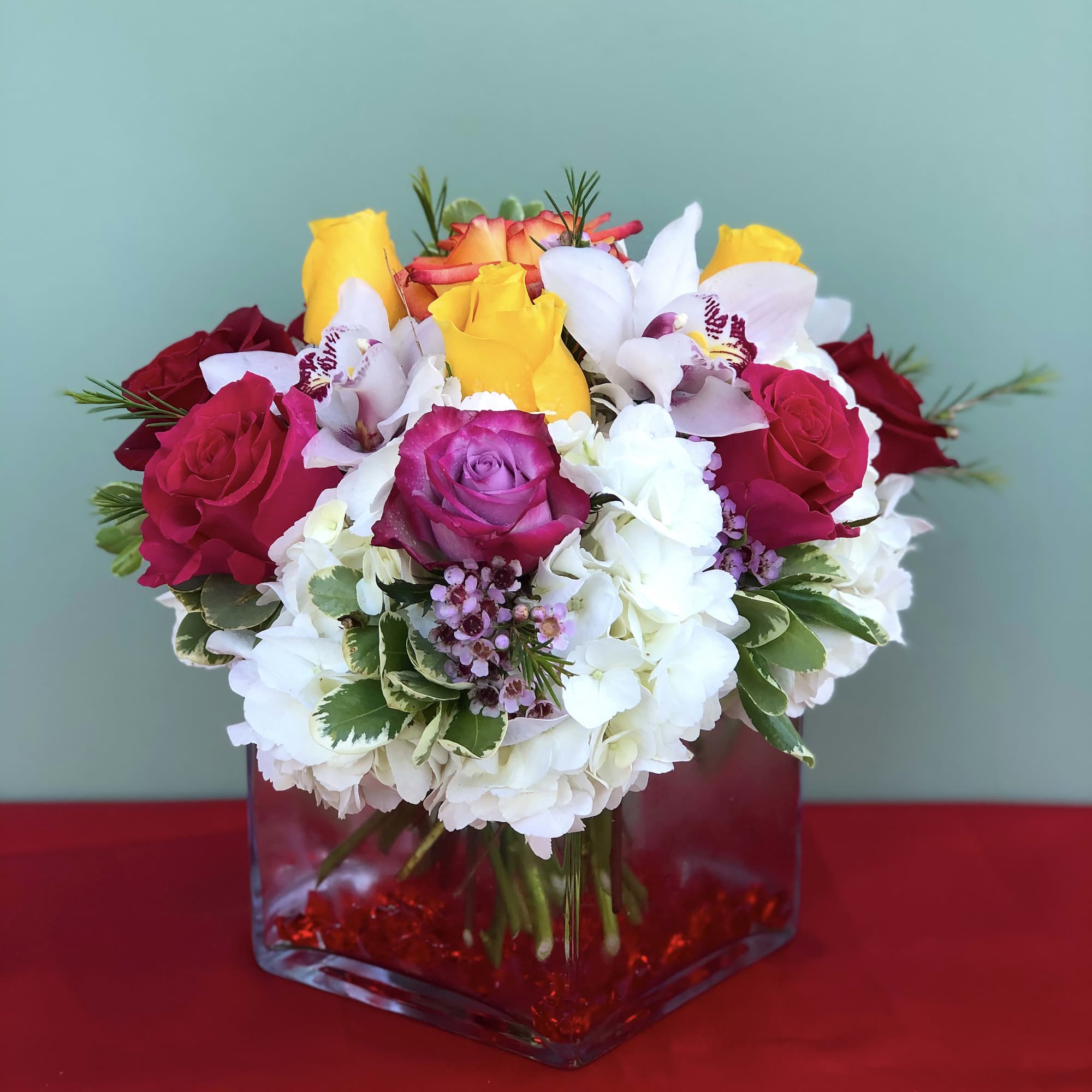 Joyful arrangement of Roses, Orchids, Hydrangeas, and Greens designed in a vase Joyful arrangement of Roses, Orchids, Hydrangeas, and Greens designed in a vase