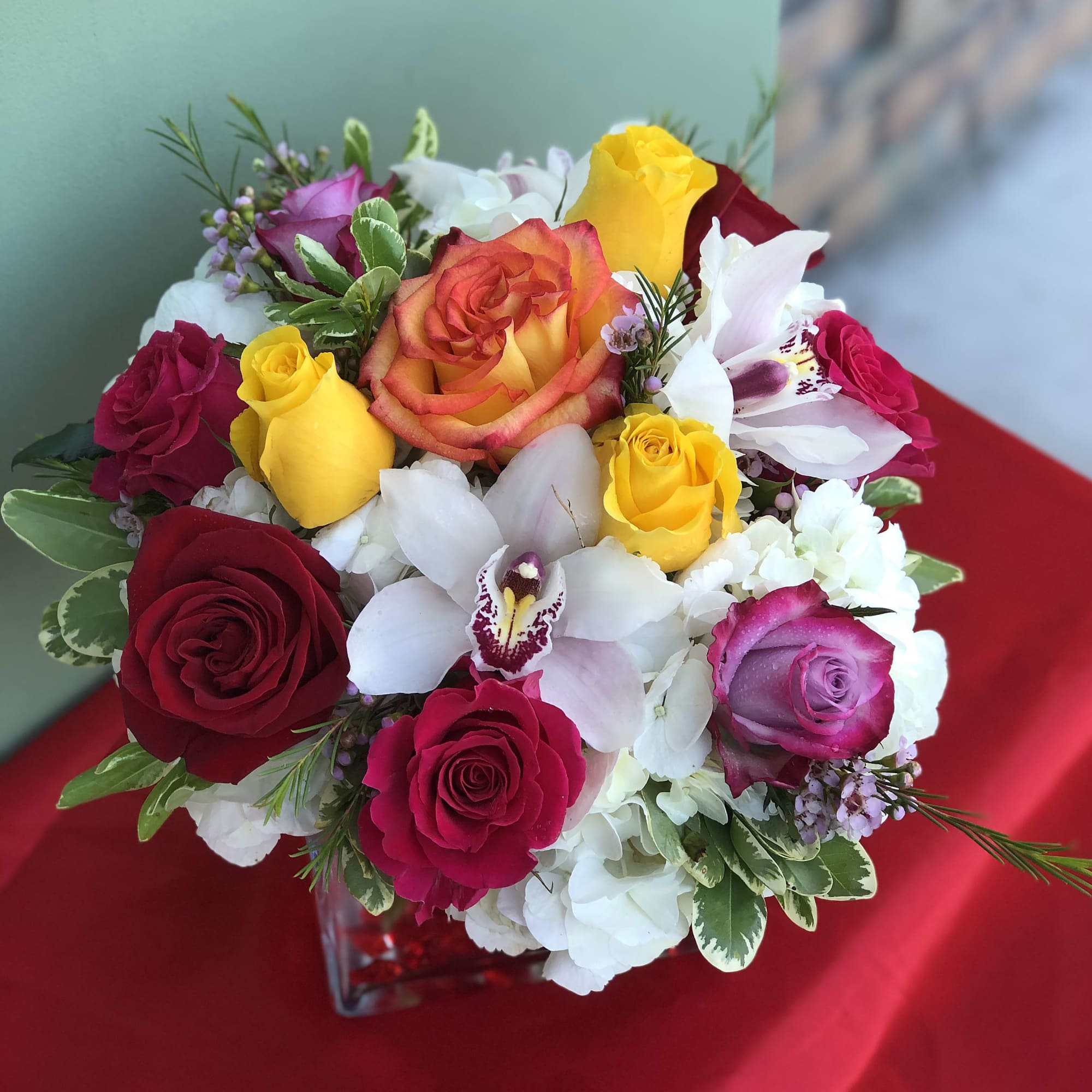Joyful arrangement of Roses, Orchids, Hydrangeas, and Greens designed in a vase Joyful arrangement of Roses, Orchids, Hydrangeas, and Greens designed in a vase