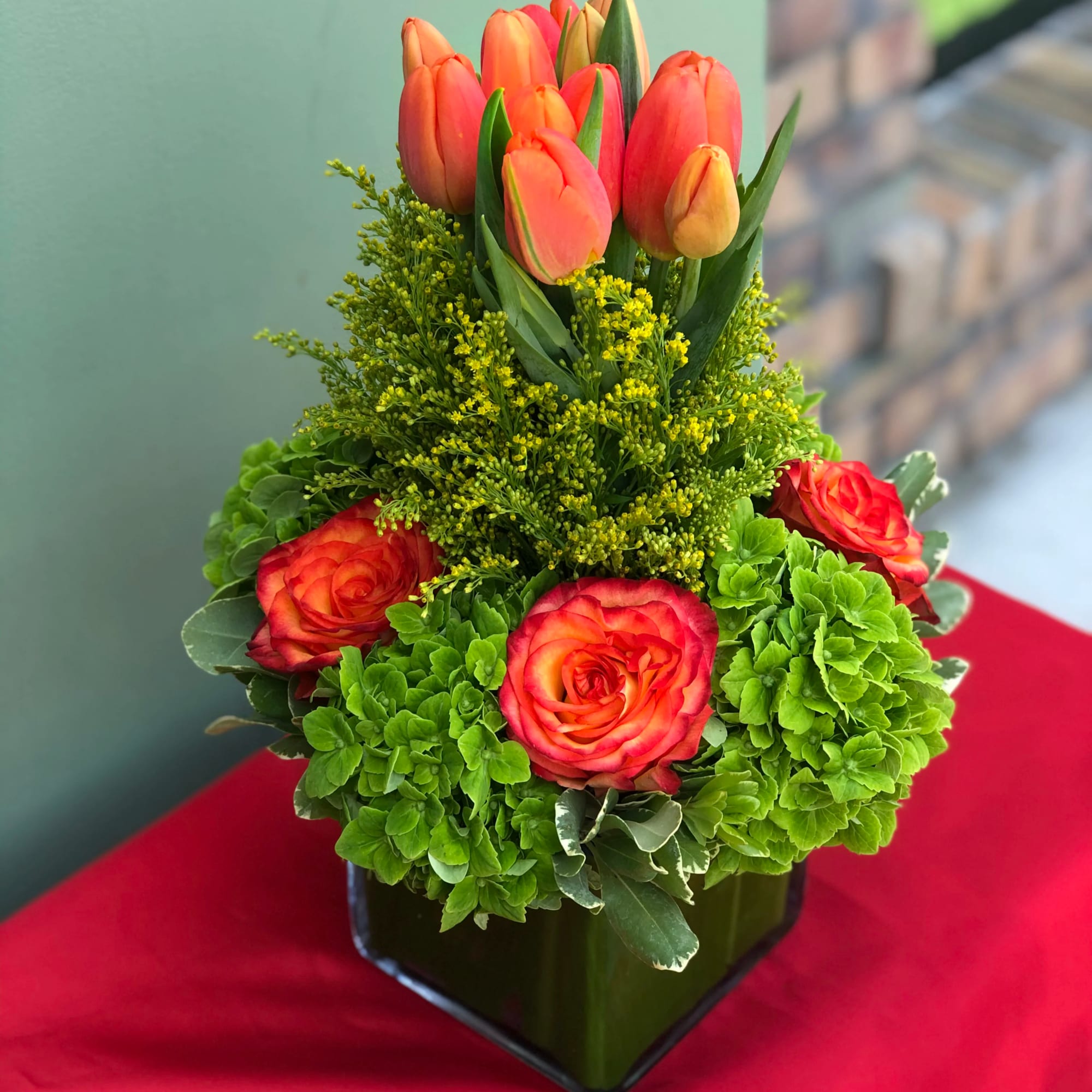 A low vase holding Roses, Hydrangeas and Tulips. 7" wide, 12" high. A low vase holding Roses, Hydrangeas and Tulips. 7" wide, 12" high.