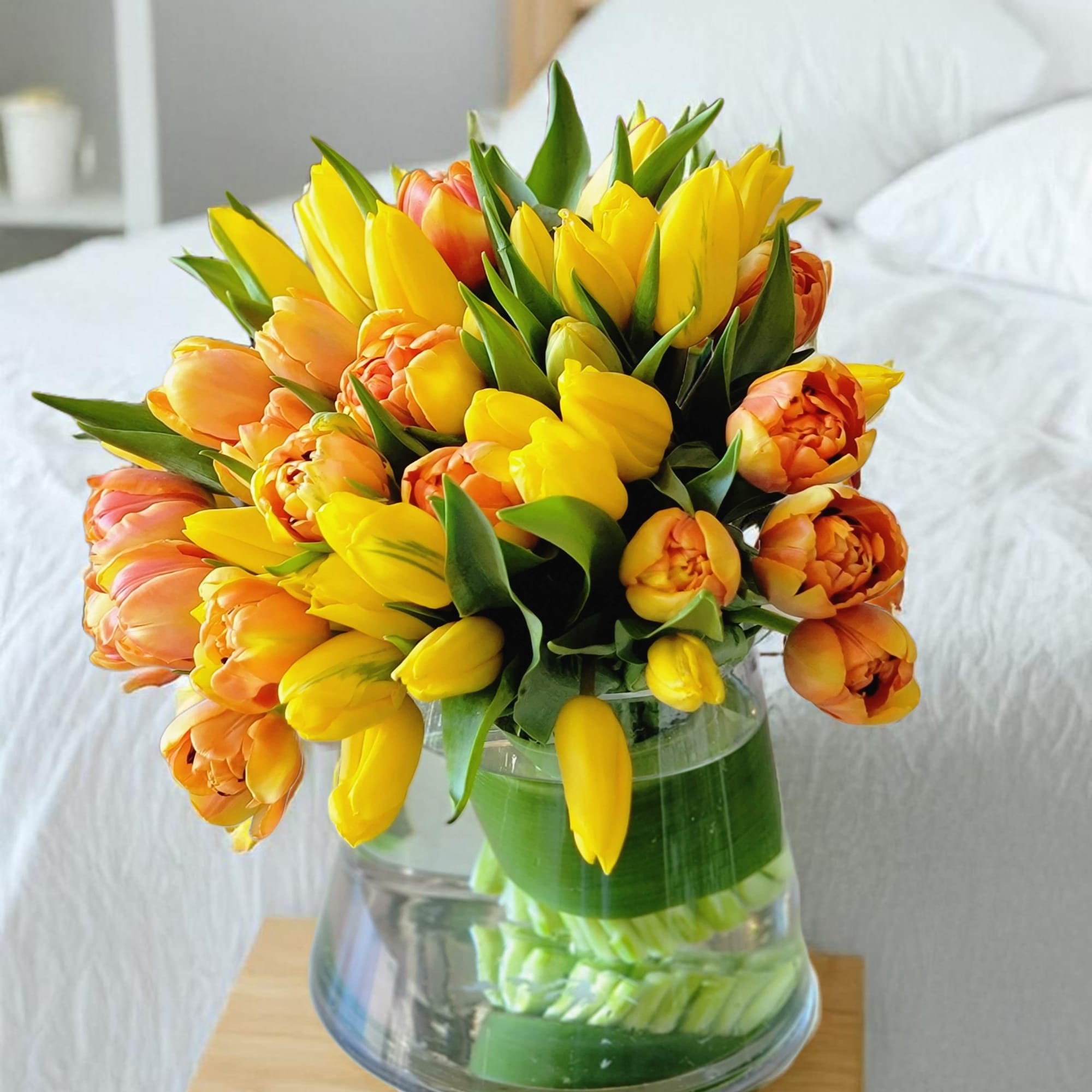 This luxurious tulip arrangement features vibrant yellow and orange tulips, artfully designed