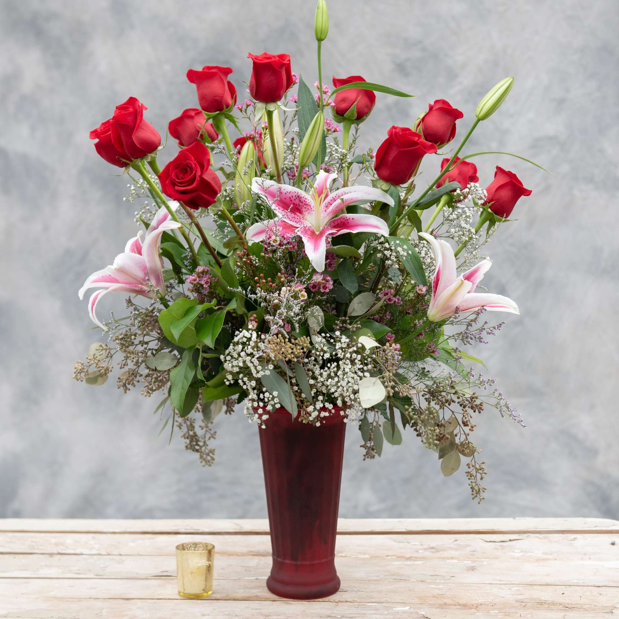 One dozen long stemmed red roses arranged with premium greens in our One dozen long stemmed red roses arranged with premium greens in our