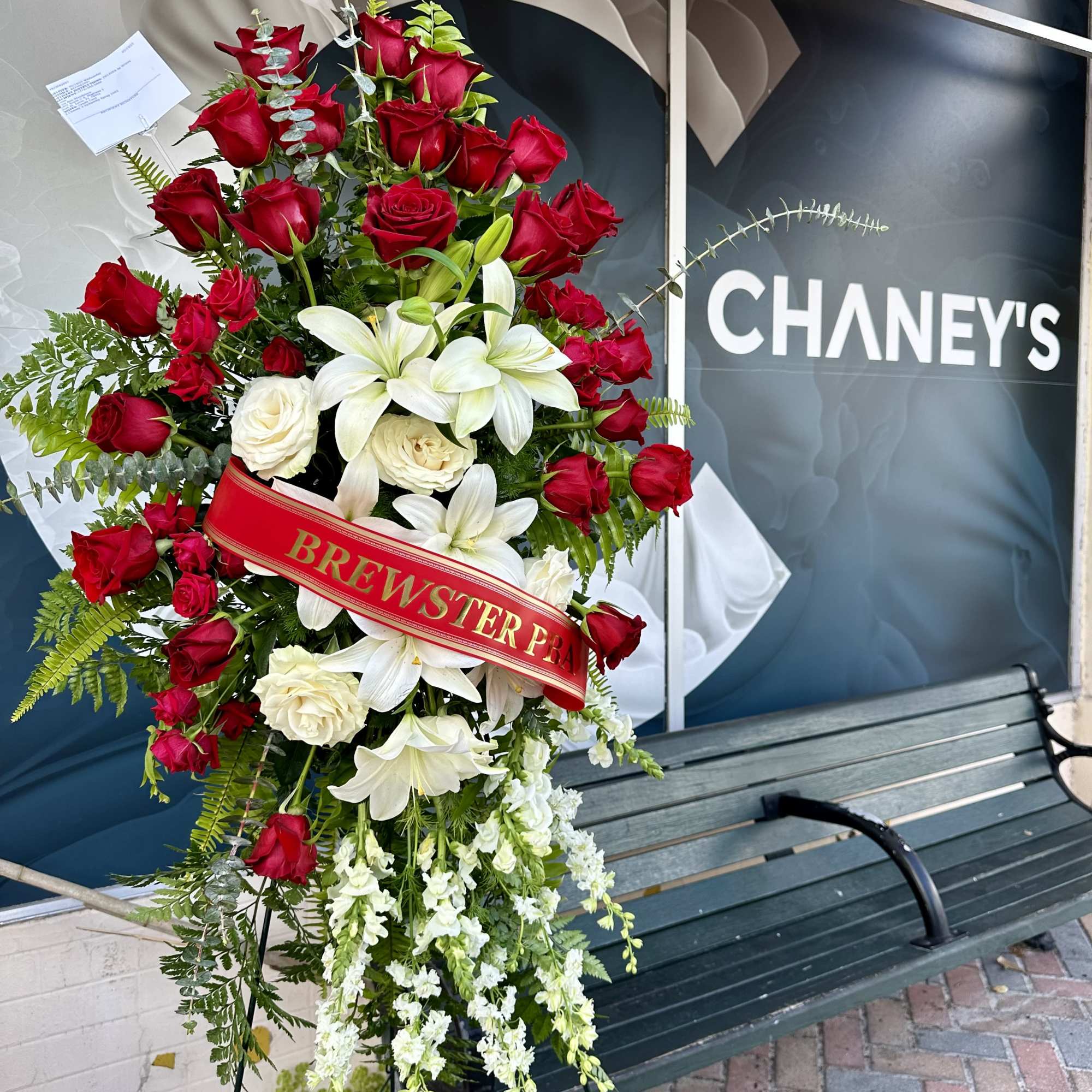 Red roses and white lilies designed with delicate greens. Optional ribbon with