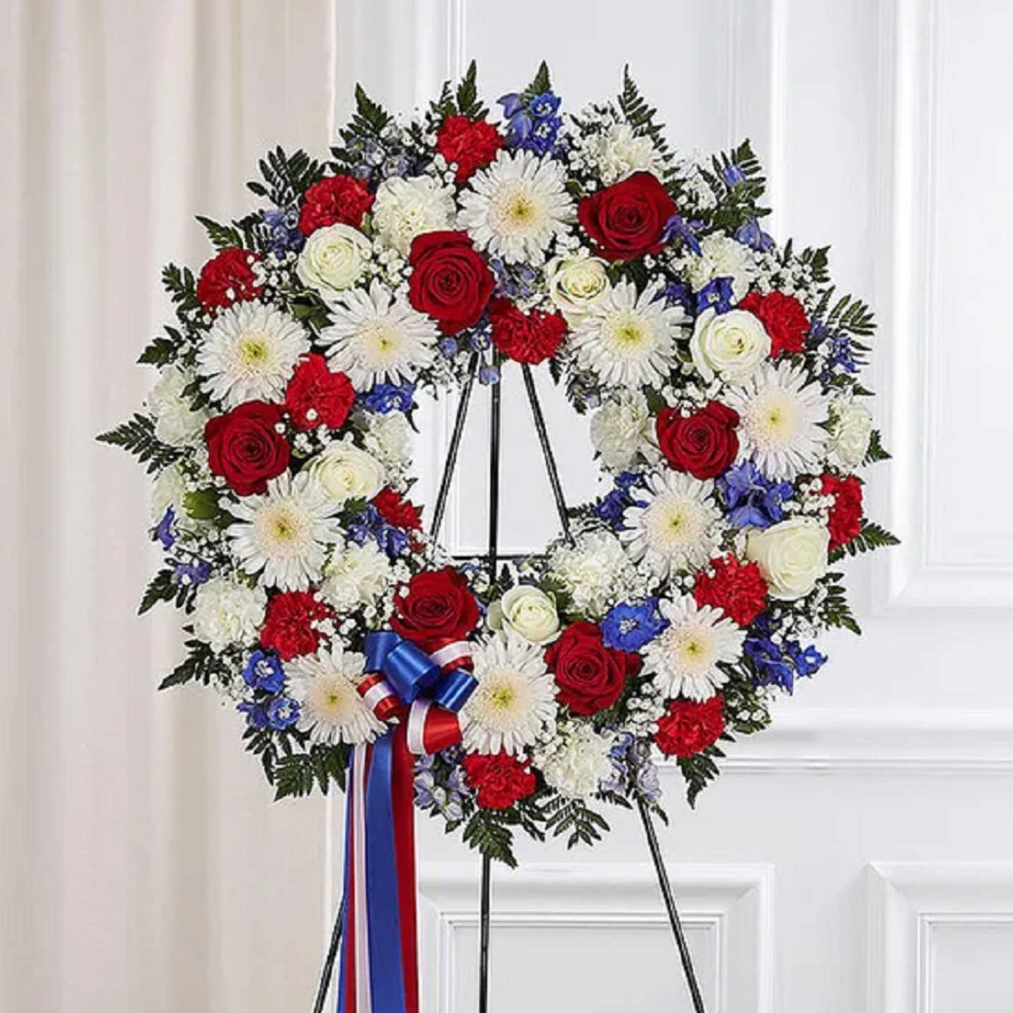 The standing wreath arrangement is meticulously crafted to honor a special someone