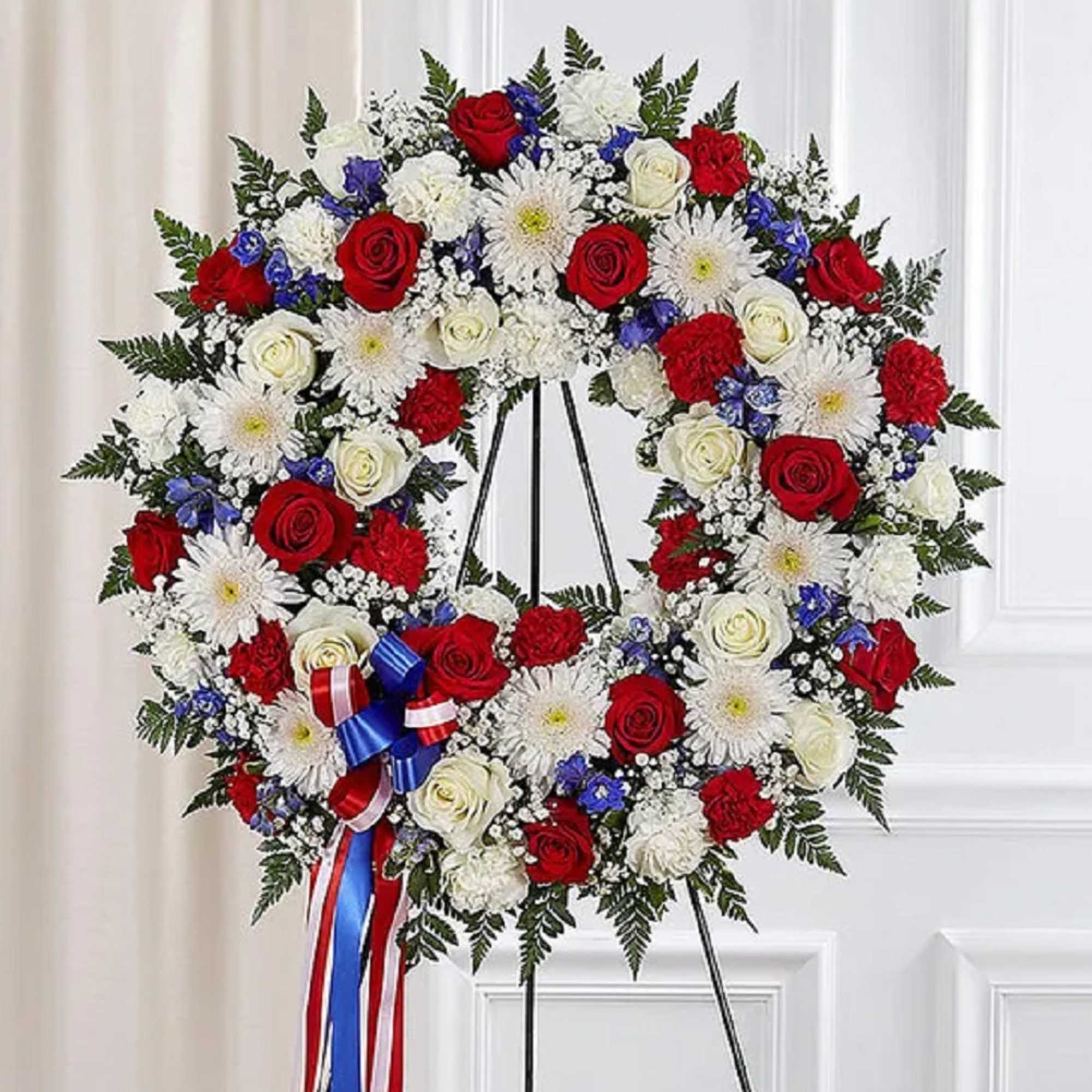The standing wreath arrangement is meticulously crafted to honor a special someone
