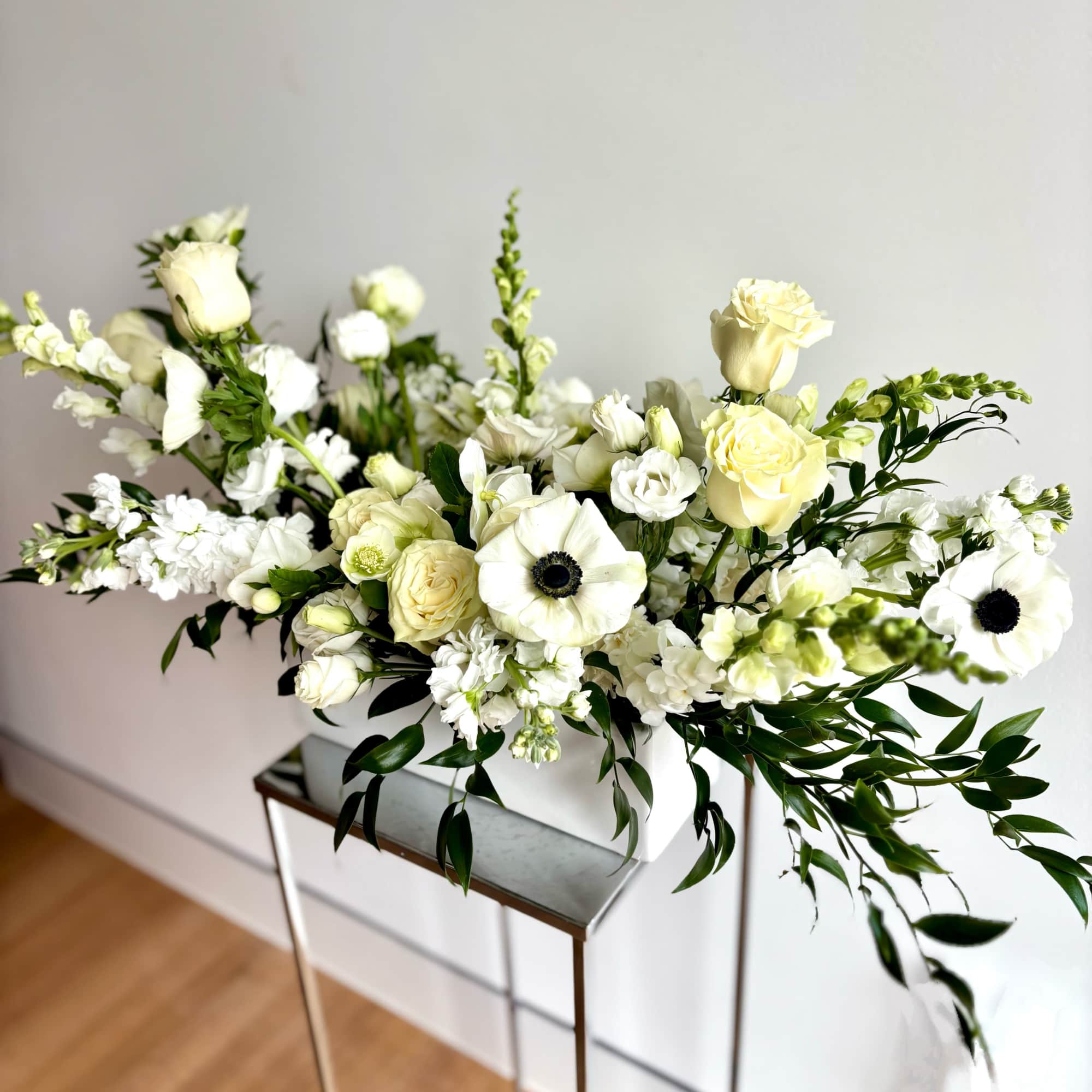 Flower arrangement with premium white blooms and dark green foliage, arranged in