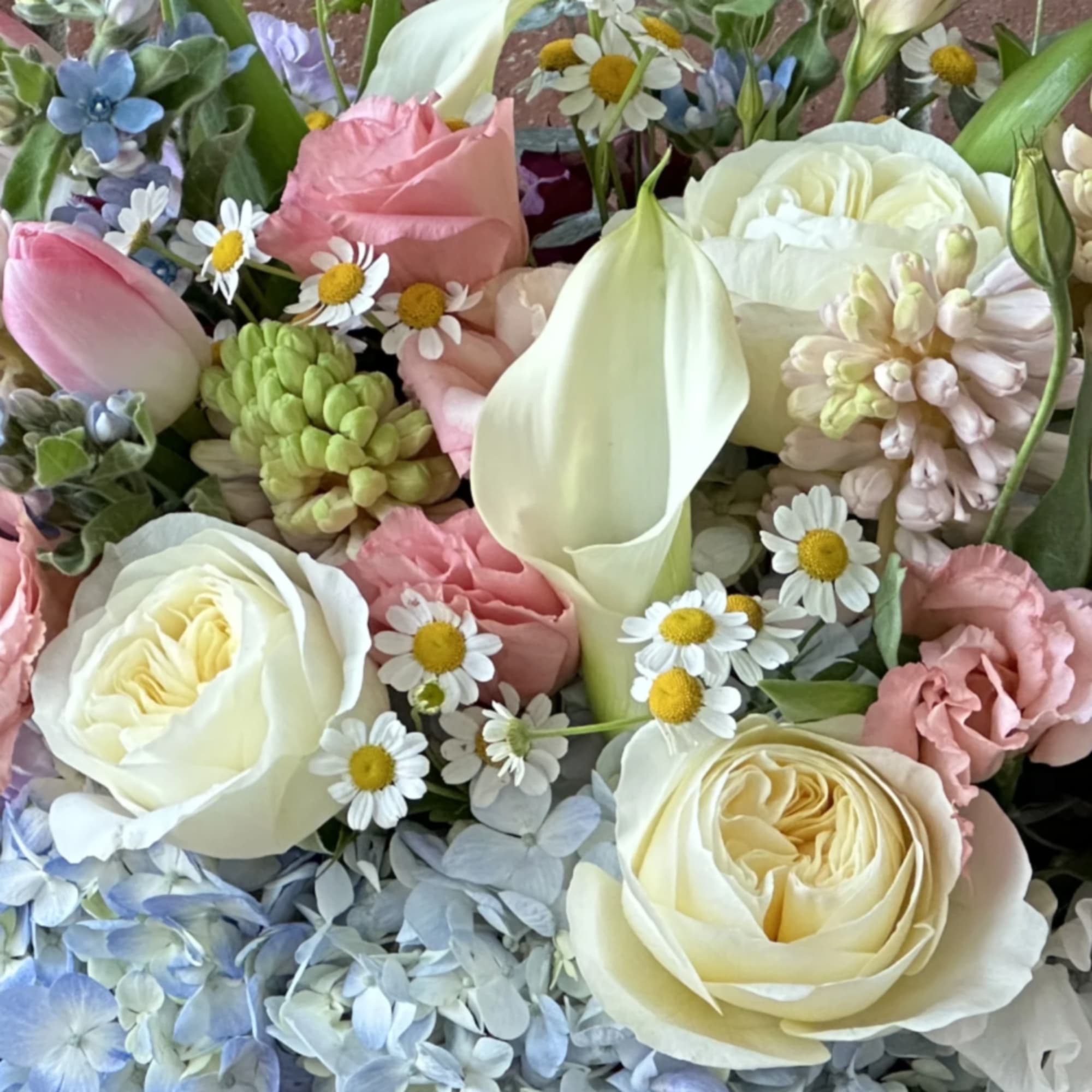 Floral arrangement in springy hues (i.e. pink, lavender, purple, yellow, white, cream