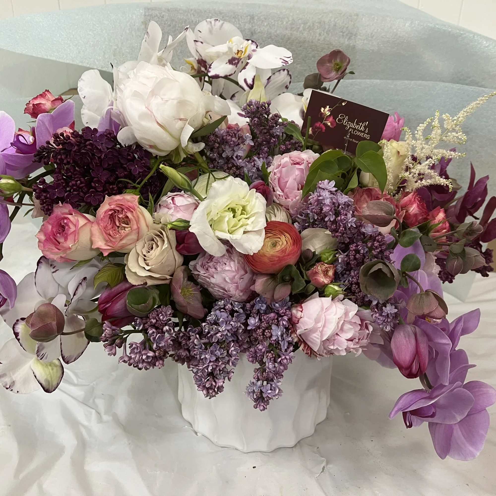 Floral arrangement in springy hues (i.e. pink, lavender, purple, yellow, white, cream