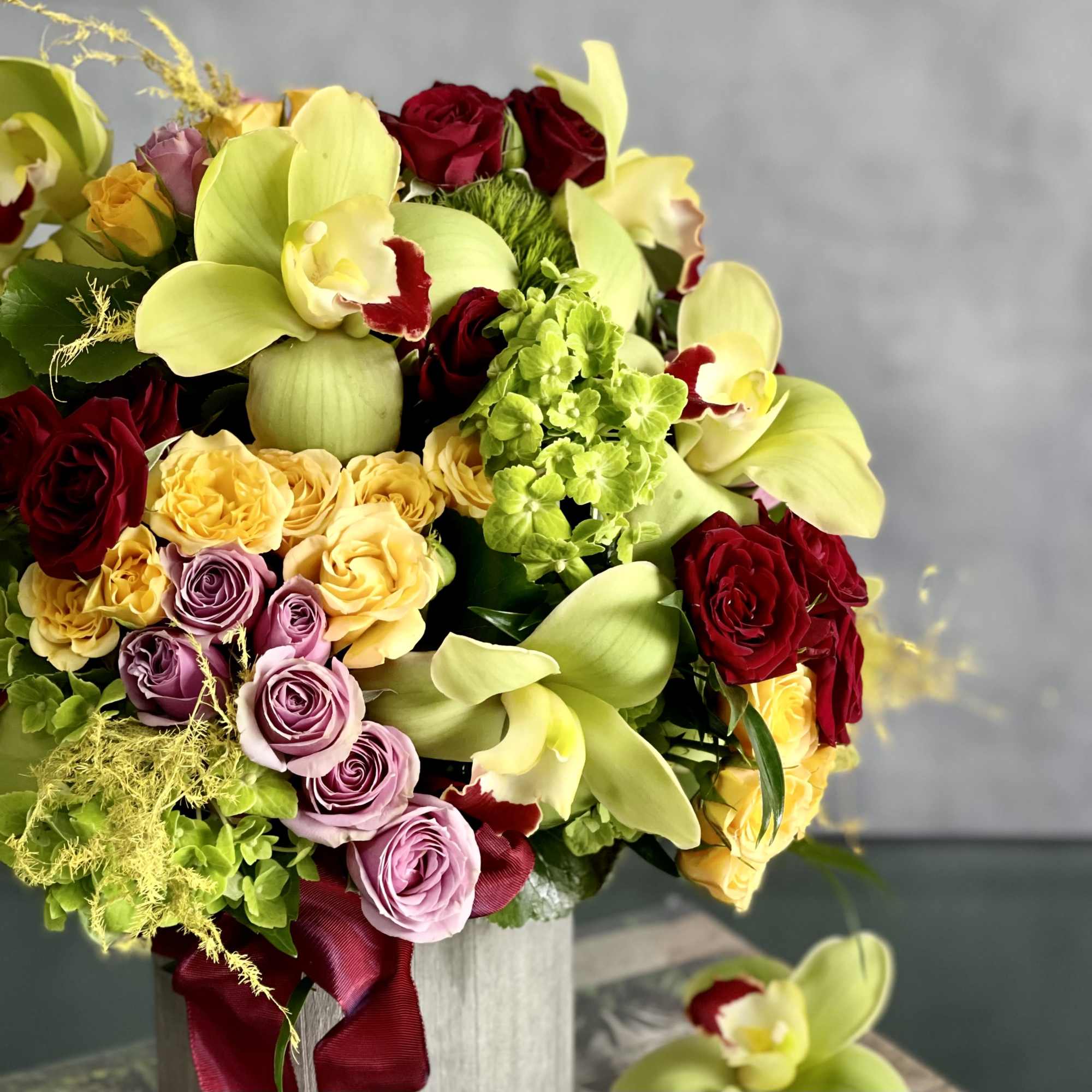 An amazing rounded bouquet of 12 vibrant green cymbidium , red, yellow