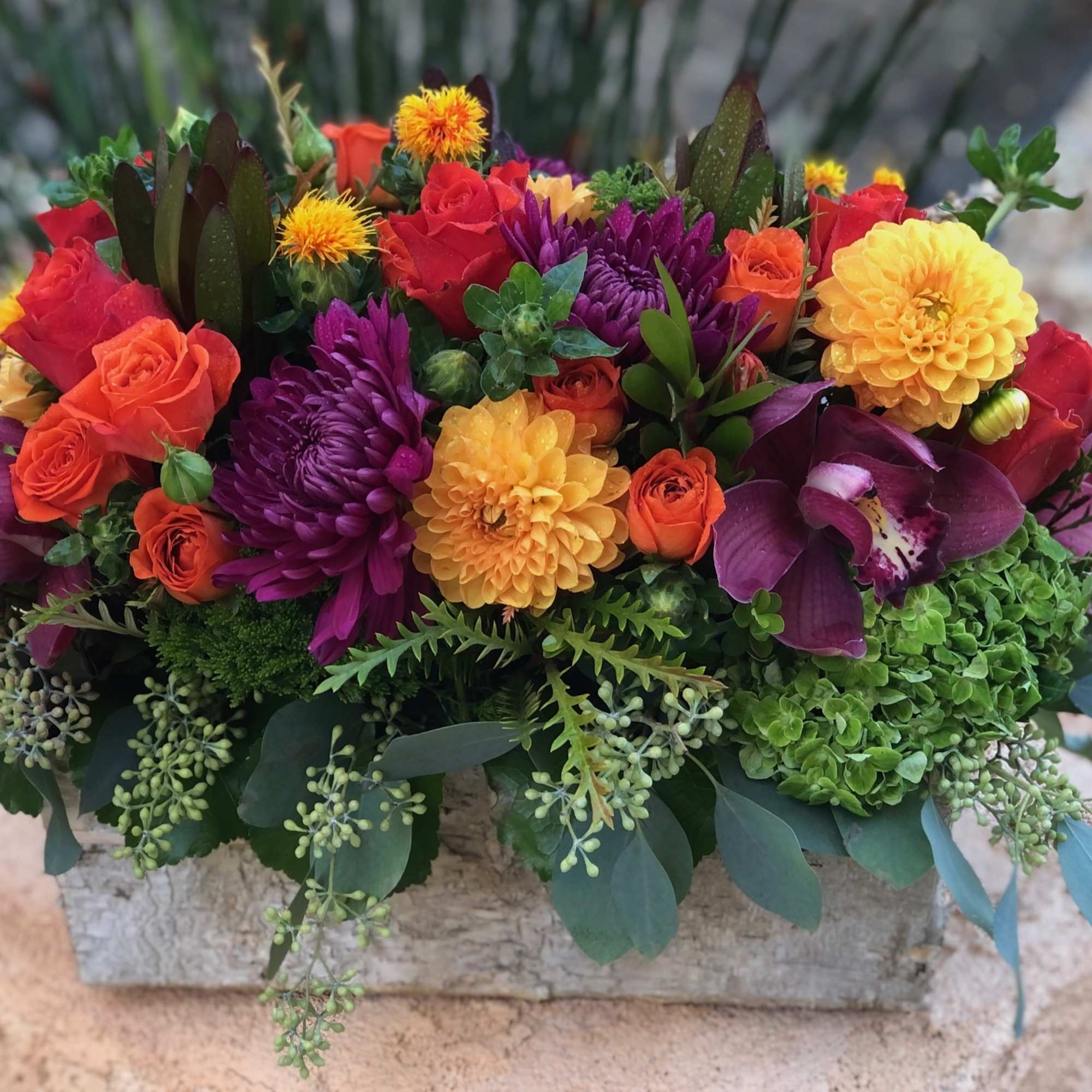 Vibrant fall blooms in an oblong birch box. Featuring Dahlias, Roses, Orchid