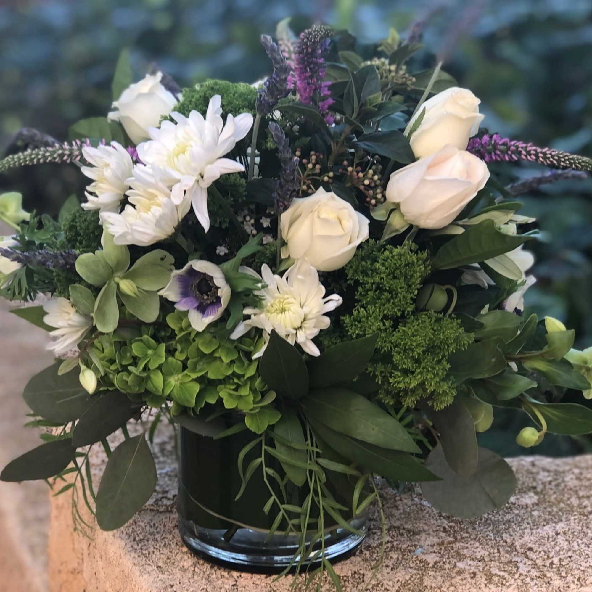 Green and white lush arrangement with accents of purple and lavender. Chunky