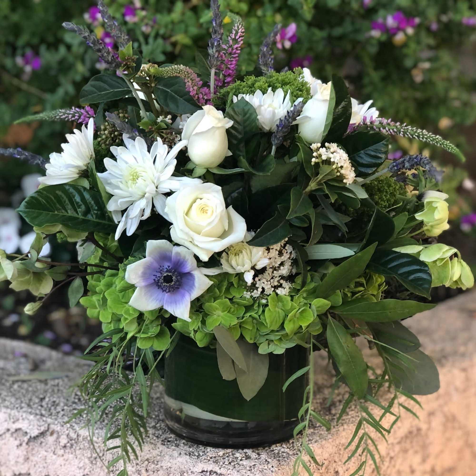 Green and white lush arrangement with accents of purple and lavender. Chunky